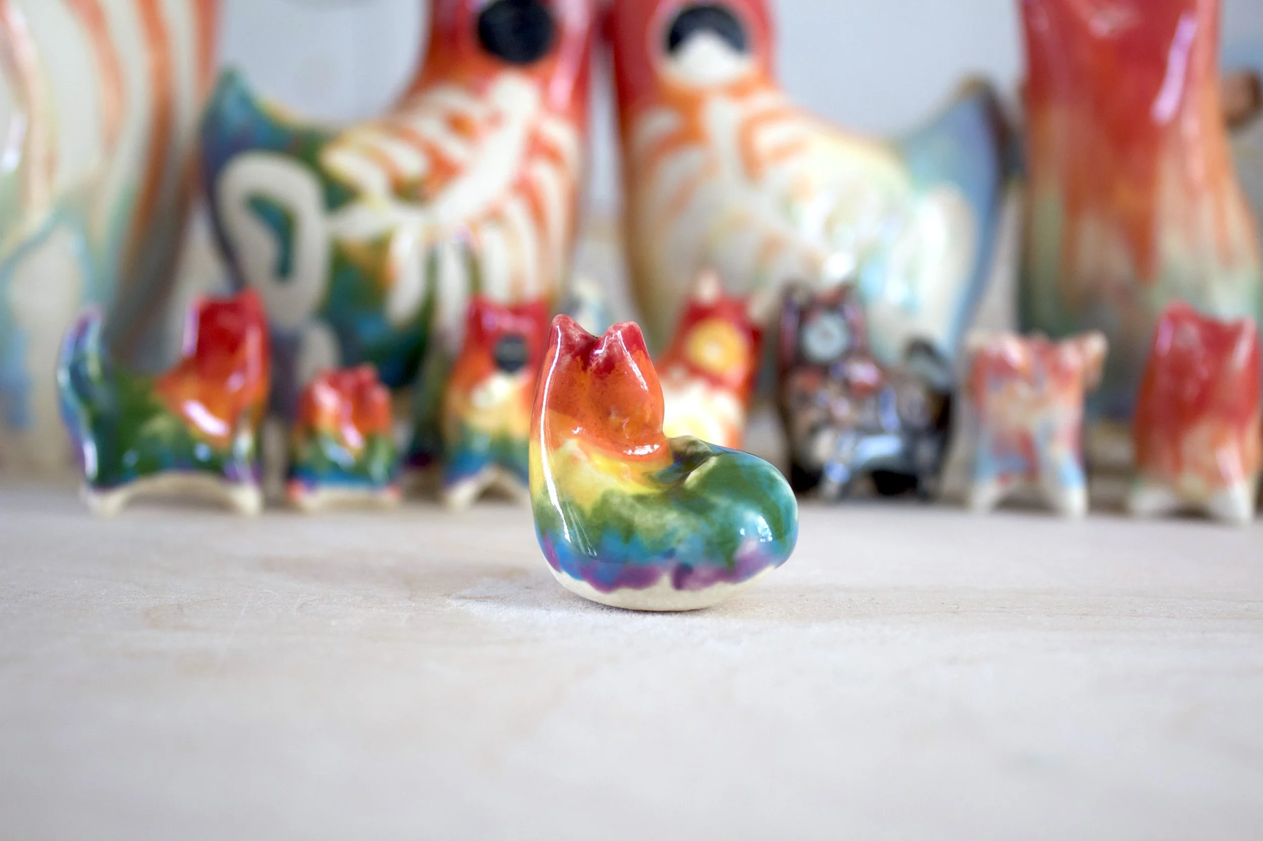 Back view of a handmade ceramic rainbow snake cat sculpture showing sculpted rainbow snake details.jpeg