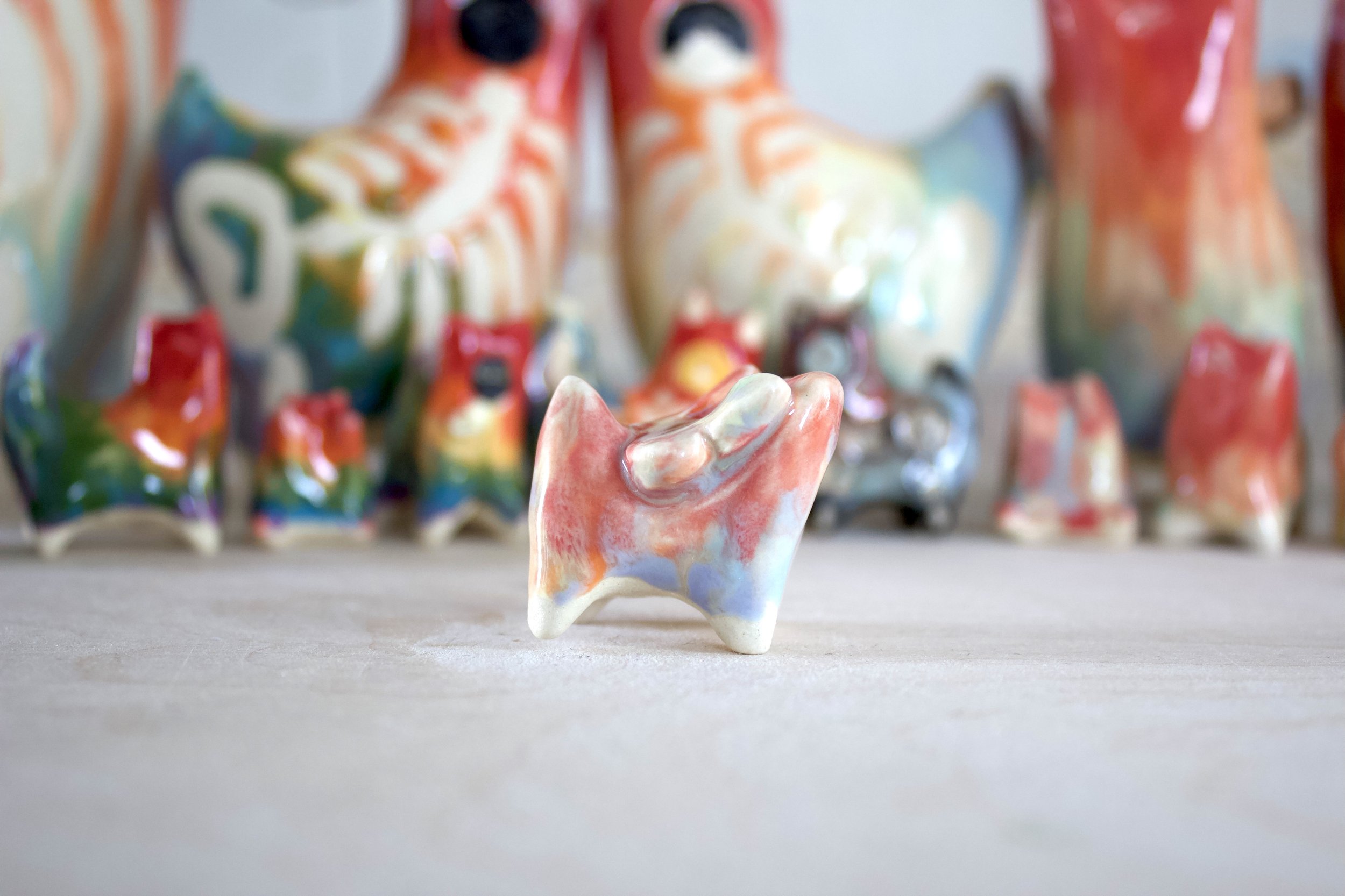 Side view of the handmade ceramic Pastel Rainbow Butterfly Cat sculpture.jpeg