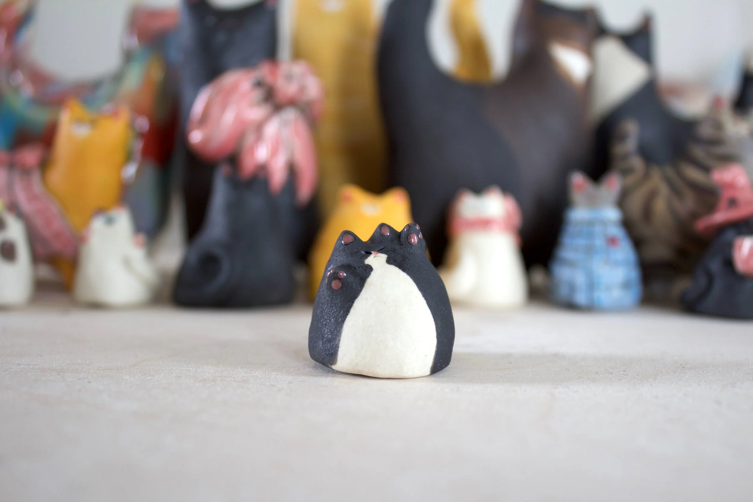 Tuxedo handmade ceramic cat chime sculpture with tiny sculpted toe beans.jpeg