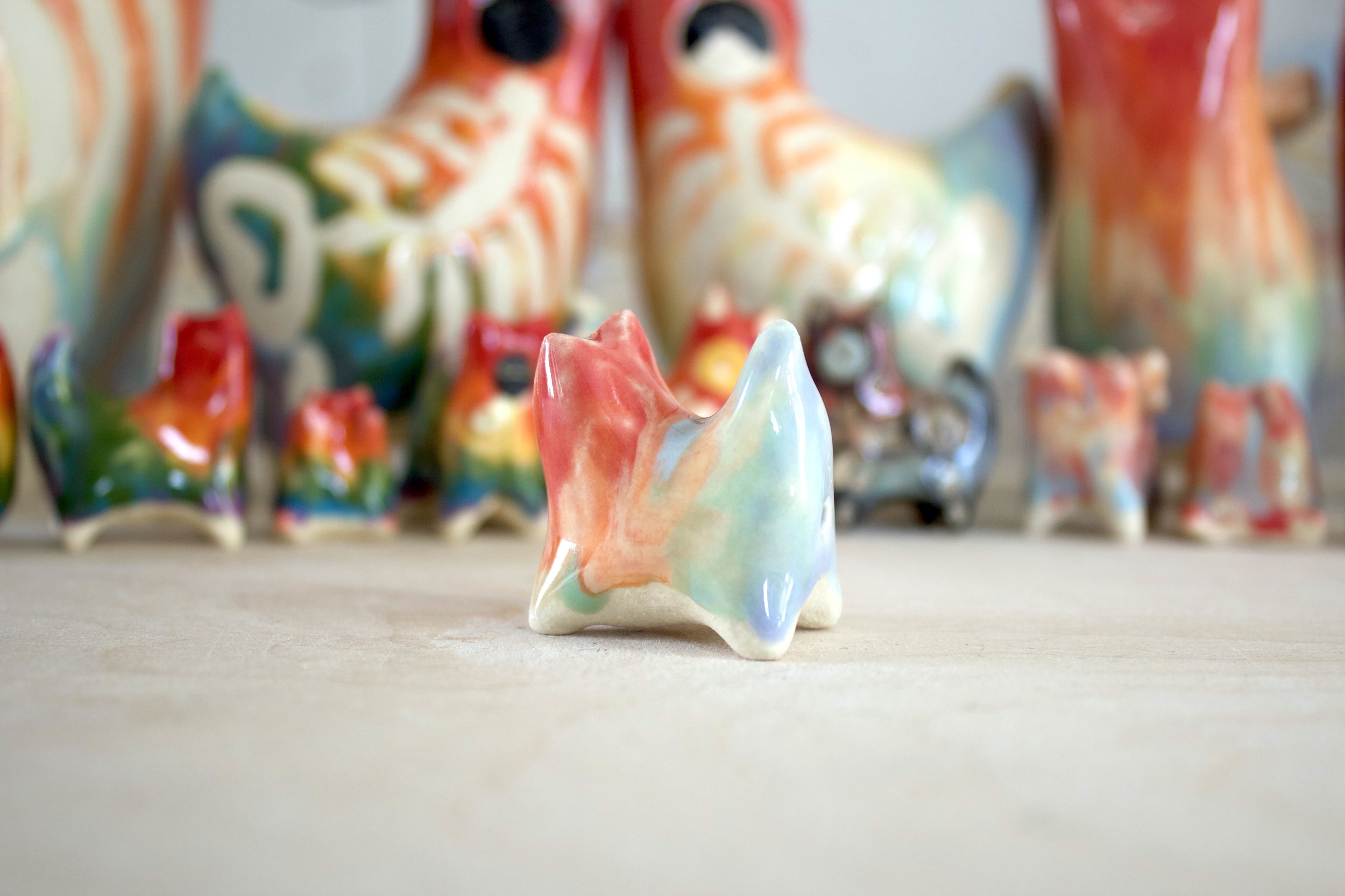 Three-quarter view of Pastel Rainbow Cat No. 2, a handmade ceramic cat sculpture.jpeg