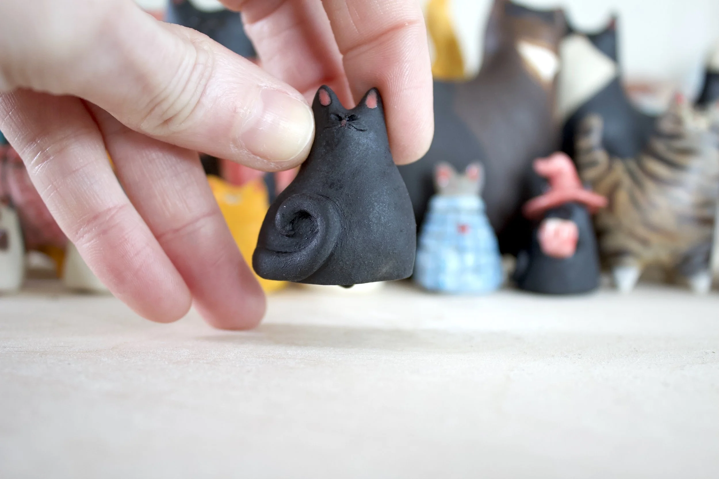 Void ceramic cat chime shown in hand for scale.jpeg