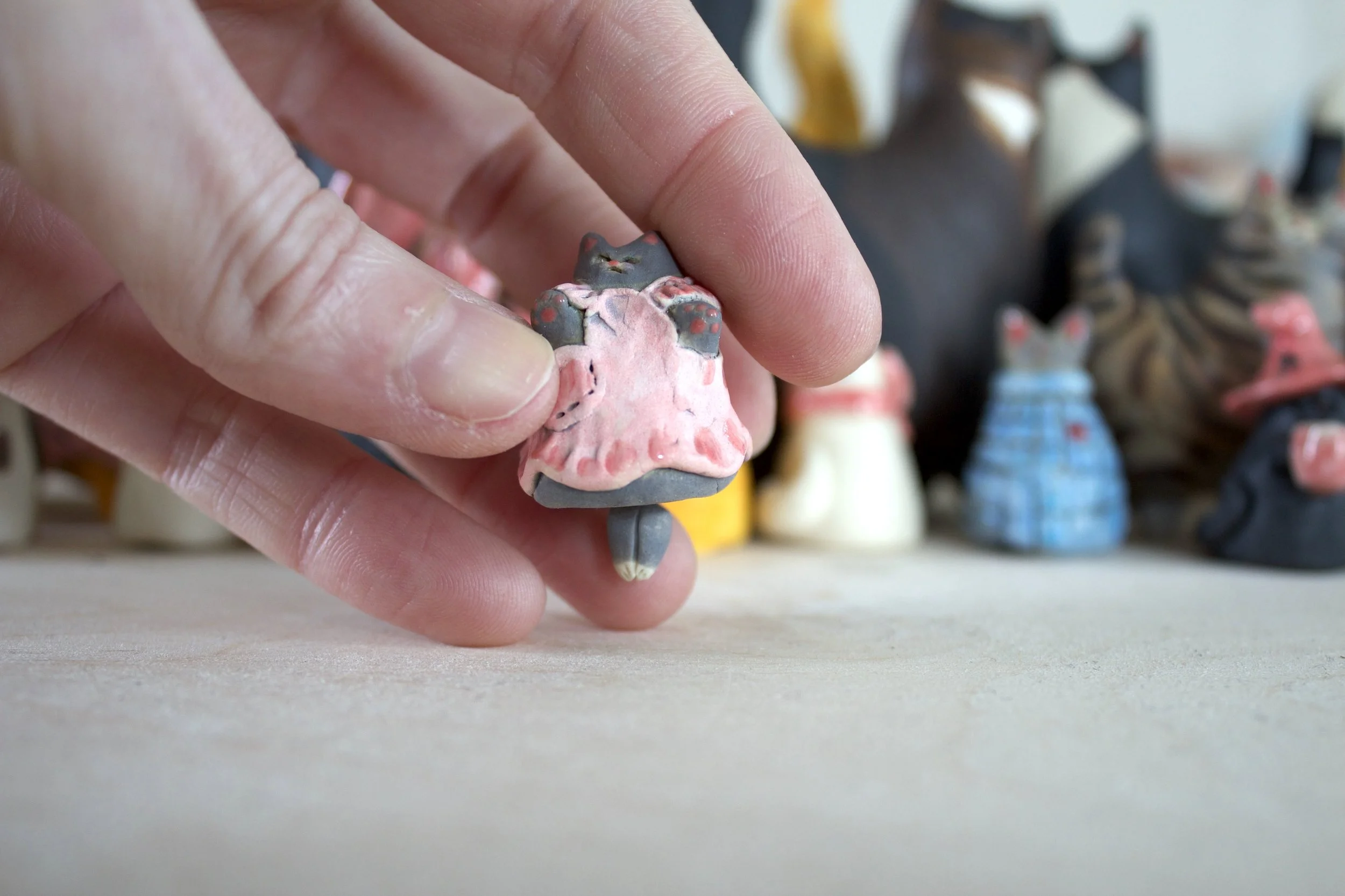 Gray ceramic cat chime shown in hand for scale.jpeg