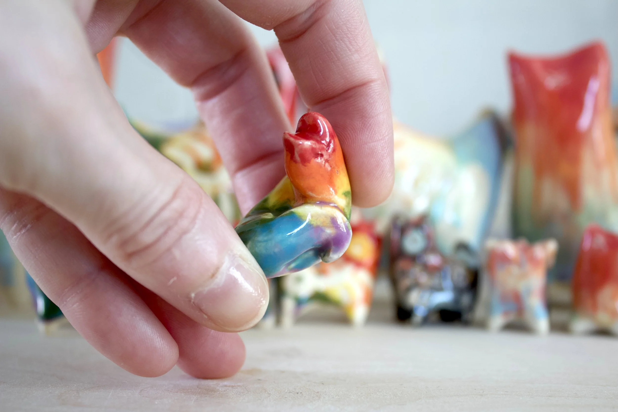 Scale view of a one-of-a-kind ceramic rainbow snake cat sculpture.jpeg