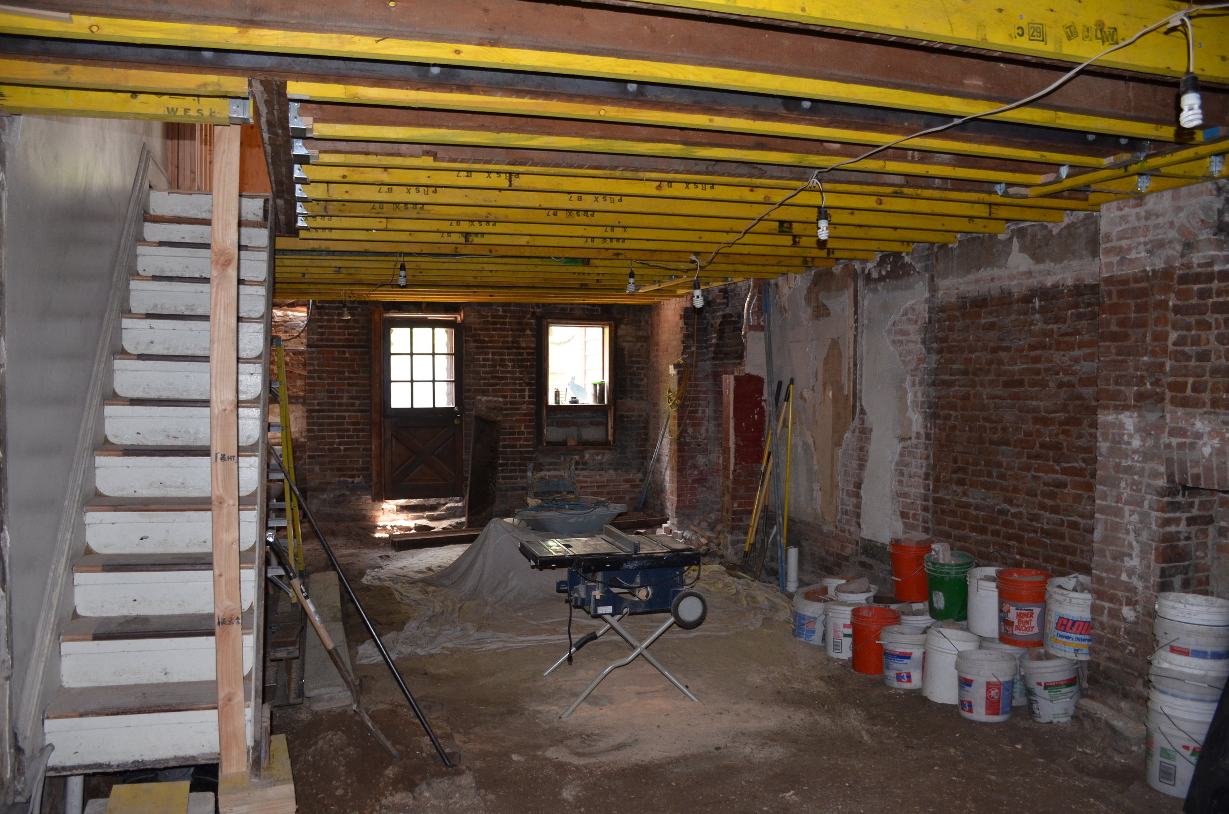 Microlam sistering of all existing floor joists, fireplace left partially demo'd. All narrow time-period staircases carefully preserved in the house to remain grandfathered in code compliance
