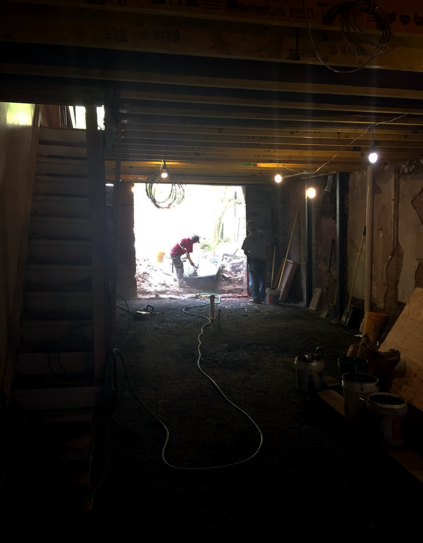 Masonry opening structurally modified for french door. Floor infilled w/ gravel base after excavation, underslab plumbing completed. Structural posts carry fireplace load above at range/oven area