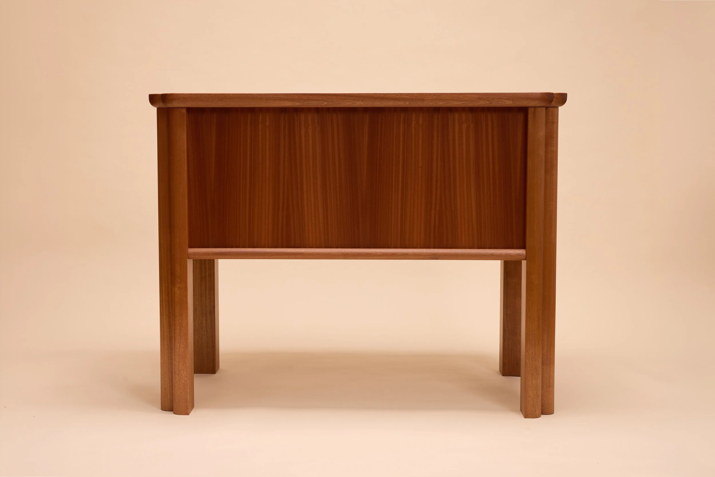 A kitchen island in sapele with zebra vertical grain, modern design against an off-white background.