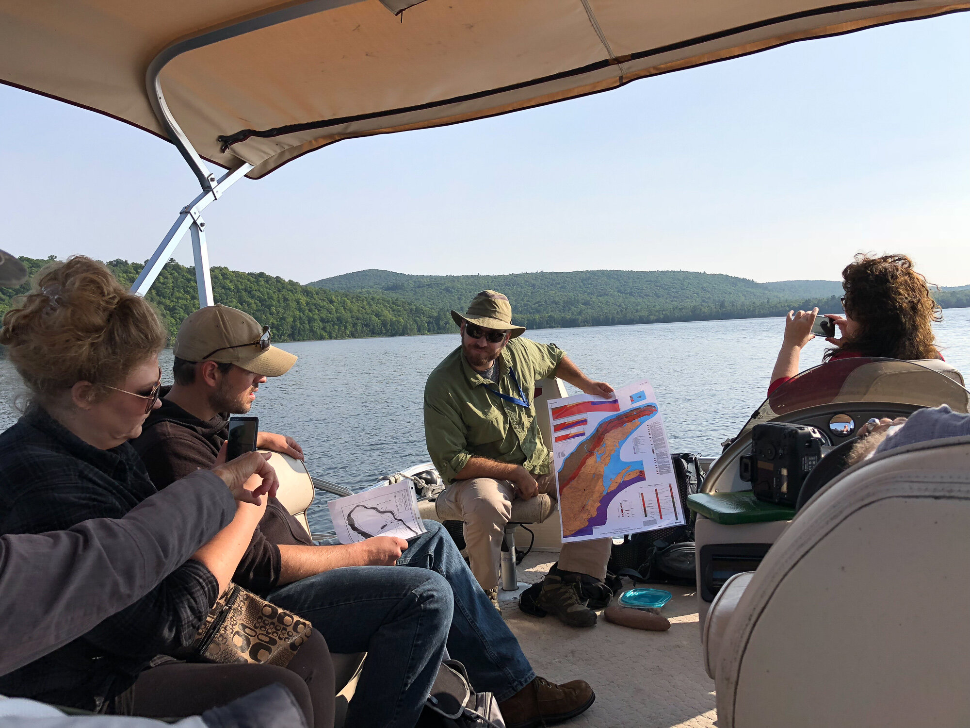   Daniel Lizzadro-McPherson leader of an August 2019 Geoheritage field trip at Gratiot Lake displays a map of the Keweenaw fault line. GLC offers field trips and workshops focused on natural history, geology, and environmental stewardship. Attendees 