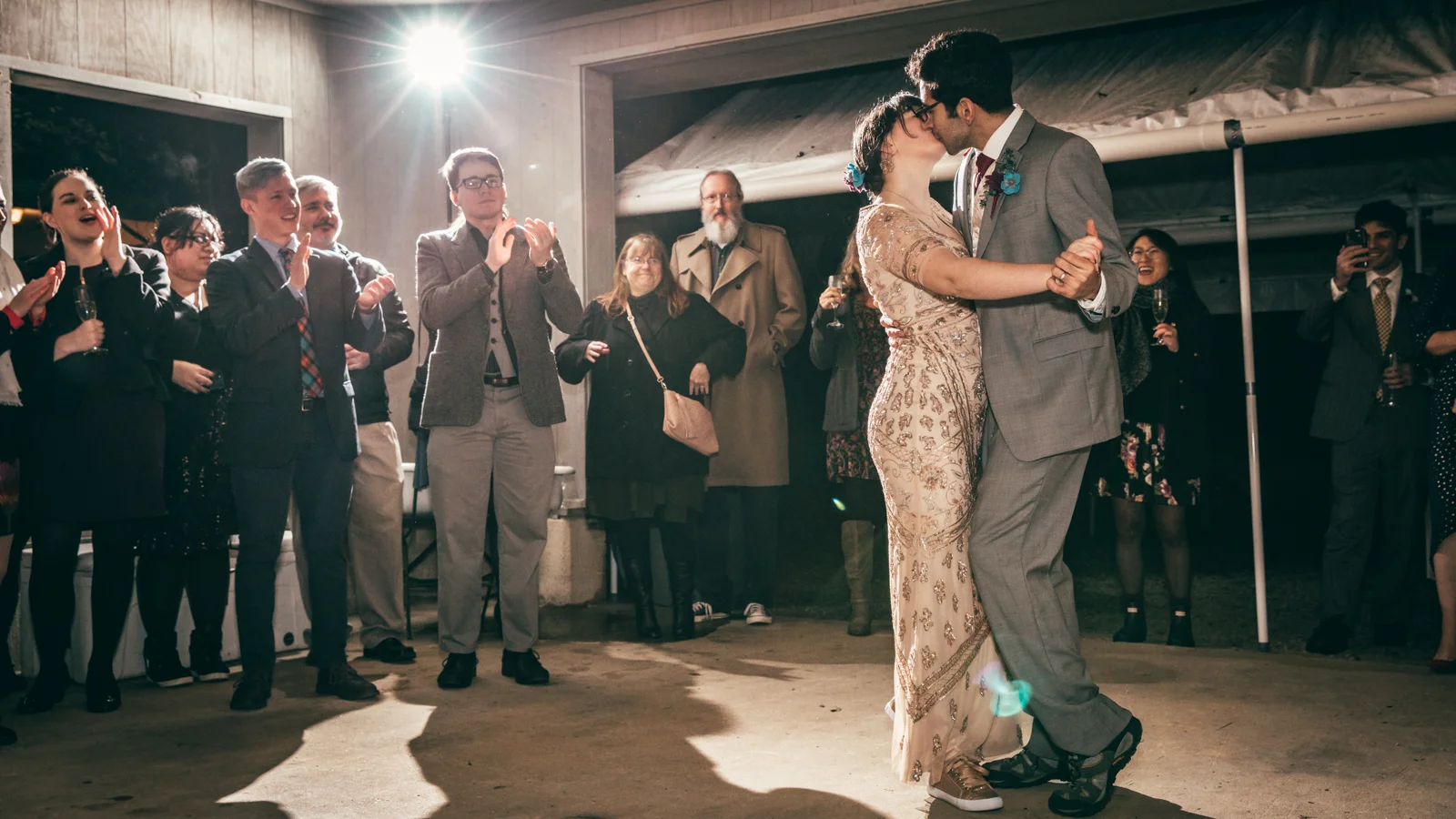 Bride and Groom share a kiss during their first dance at an outdoor wedding reception