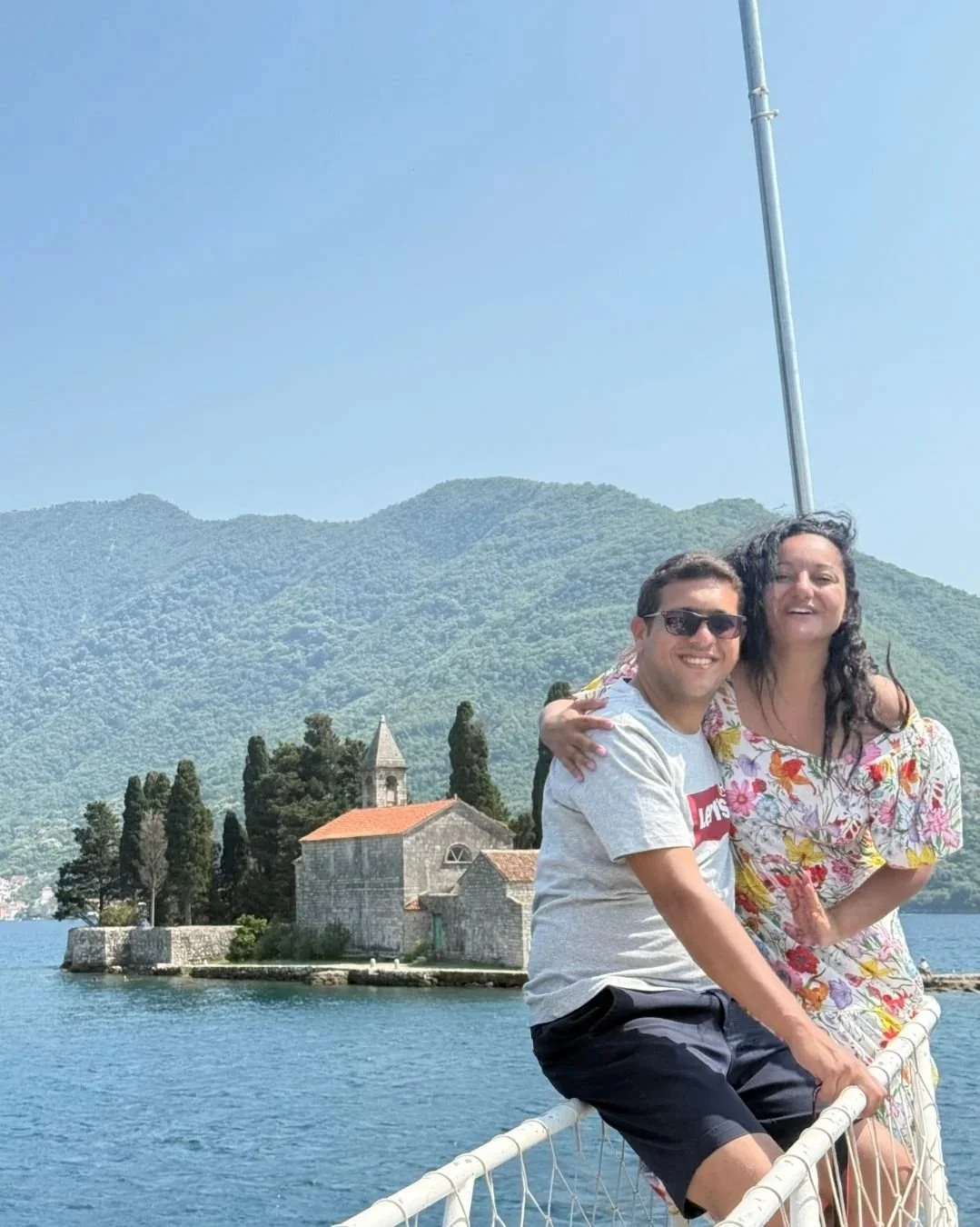 Couple enjoying a boat ride with a view of St. George Island in Perast, Montenegro