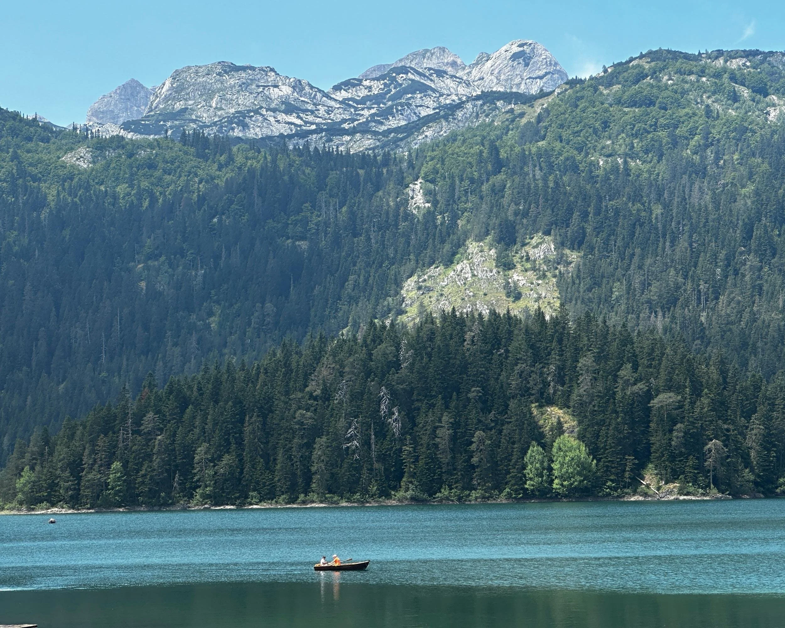 black lake in durmitor with a boat in the lake