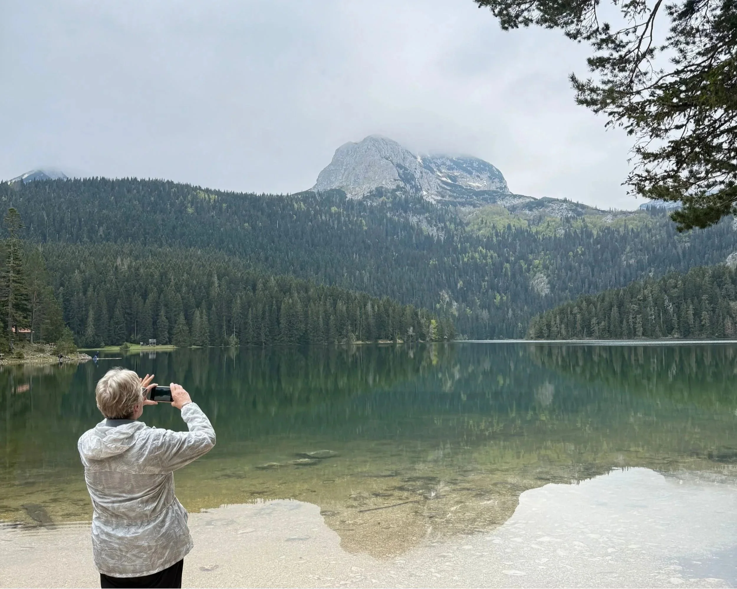 Woman taking a photo of Crno Jezero in Durmitor National Park, Montenegro.
