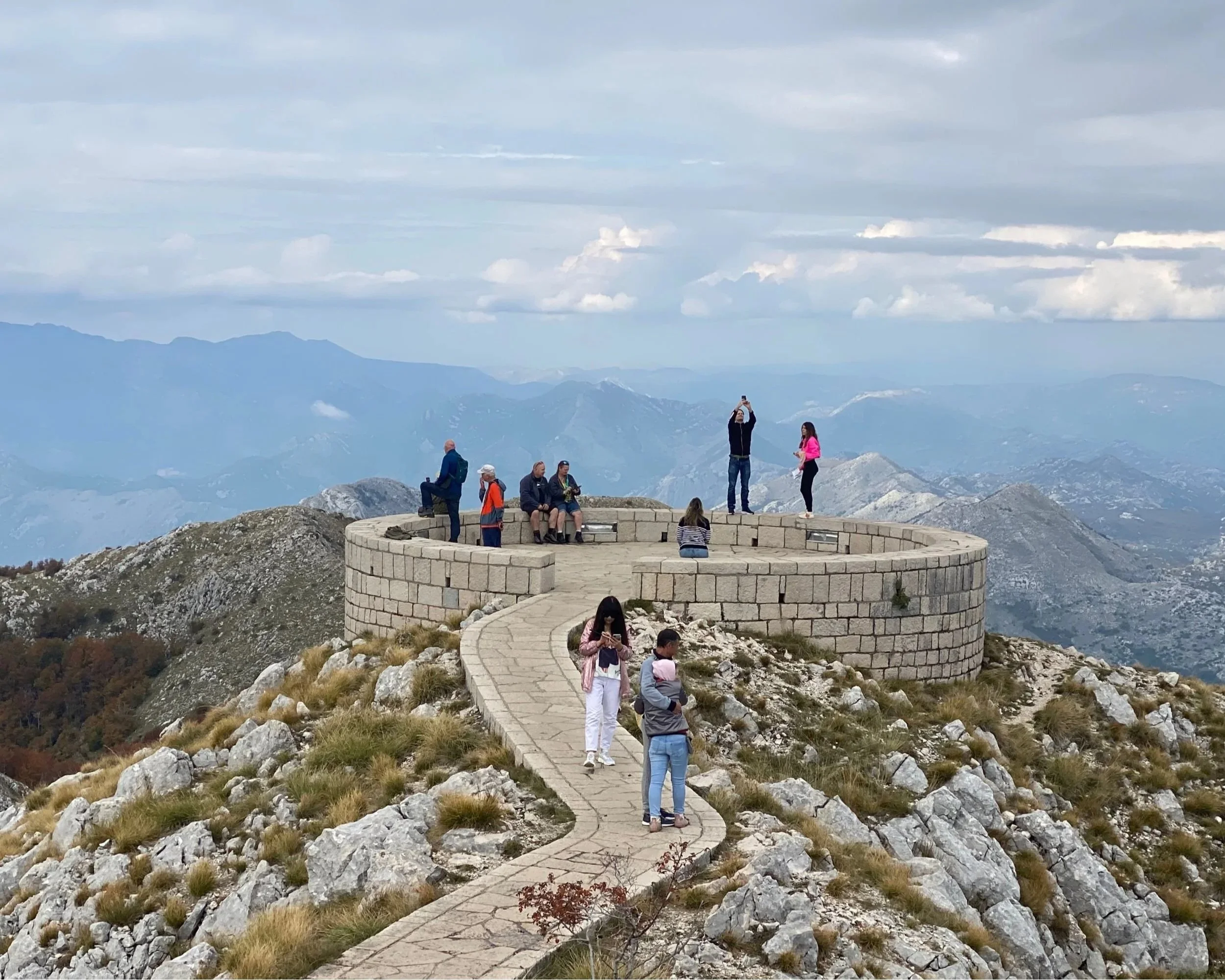 Tourists photographing the panoramic view from Mount Lovćen in Montenegro.