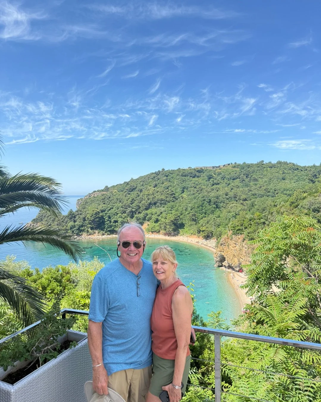 Smiling couple enjoying the view of a beautiful beach in Montenegro