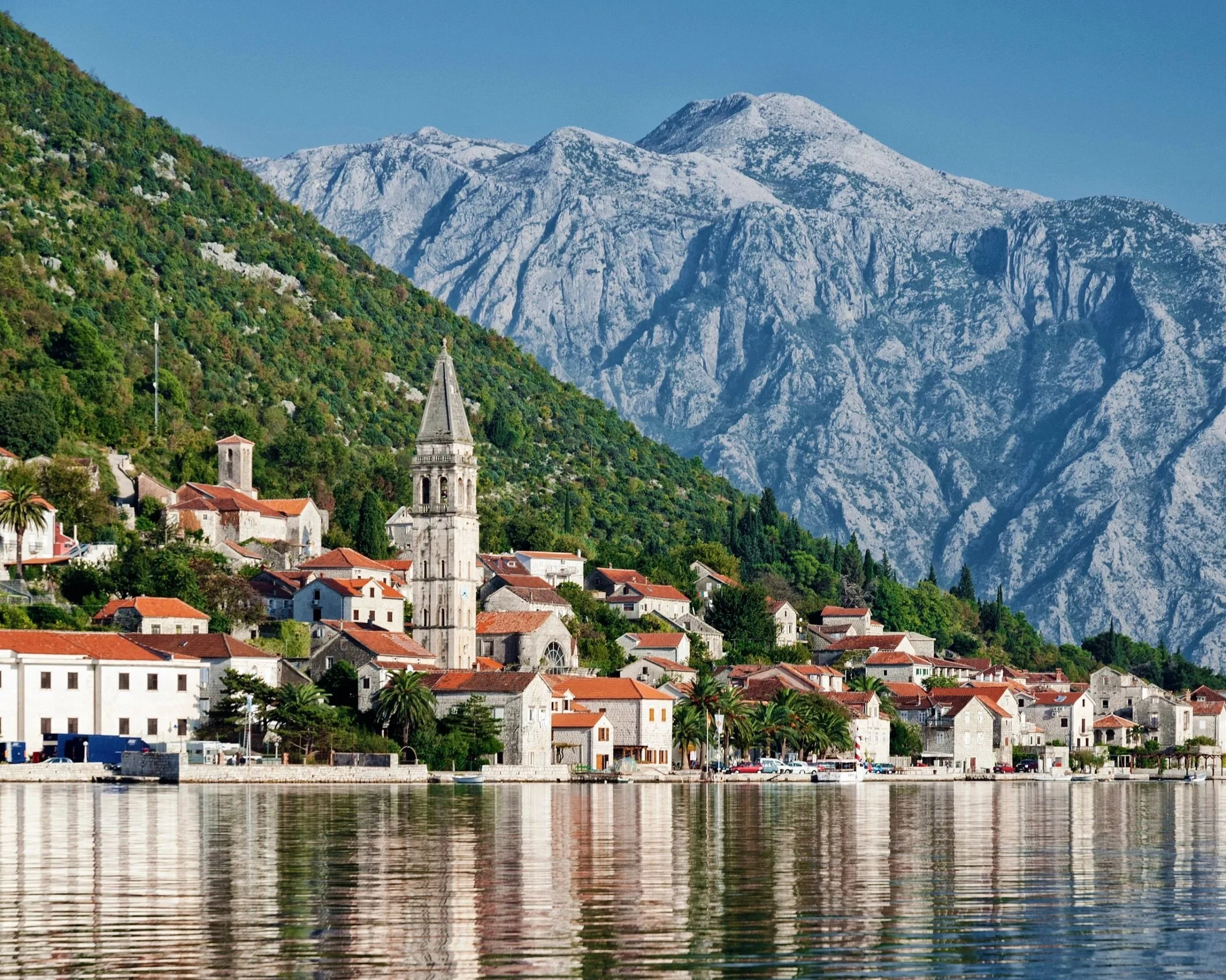 Stone houses along the waterfront in Perast with the Bay of Kotor in the background