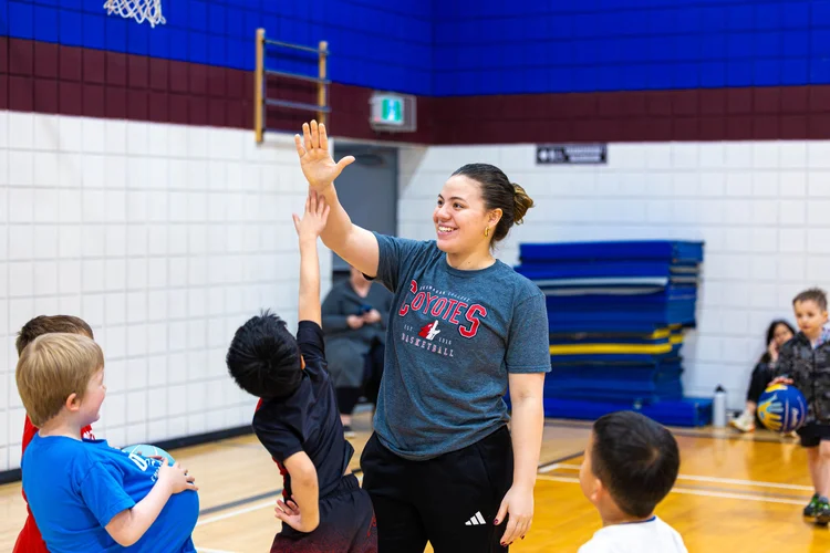Coach Anto Luraghi high fiving young Junior Coyotes players in Kelowna