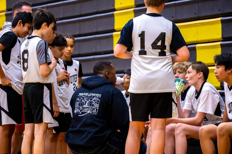 Coach Rick Shaw talking to his Junior Coyotes boys team in a huddle
