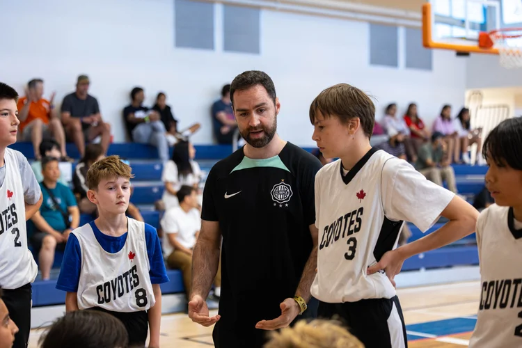 Coach Andrew Gini talking with Junior Coyotes players at a game in Kelowna