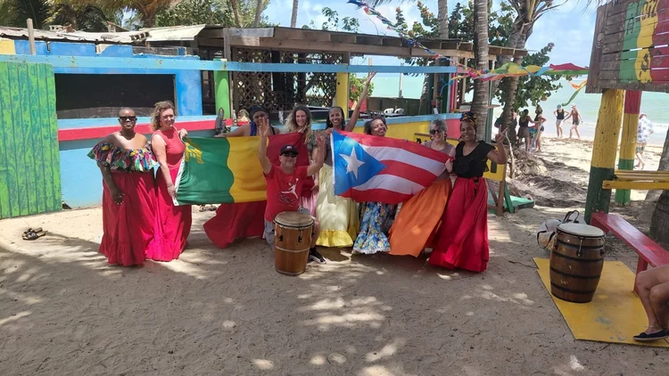 Anjua with the group at a Puerto Rico beach bar, flags raised
