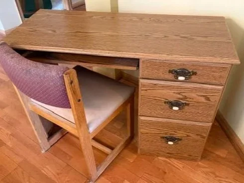 Desk with chair. Roll out keyboard tray with three drawers on right side.
