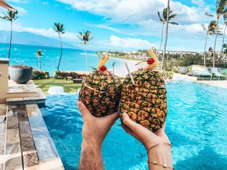 Photo of Mai Tai cocktails overlooking a beachfront pool.