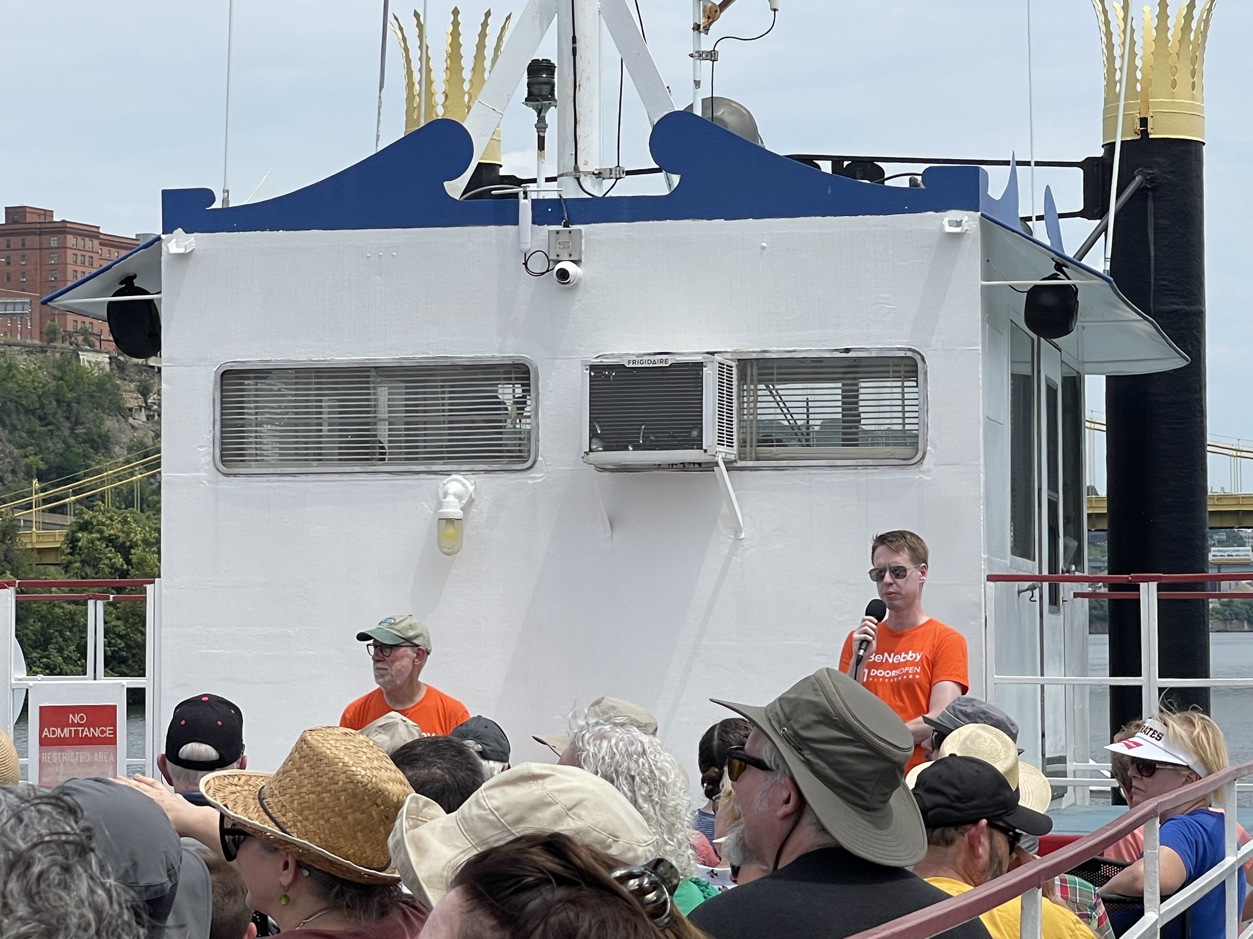  Speakers talk to crowd at boat tour. 