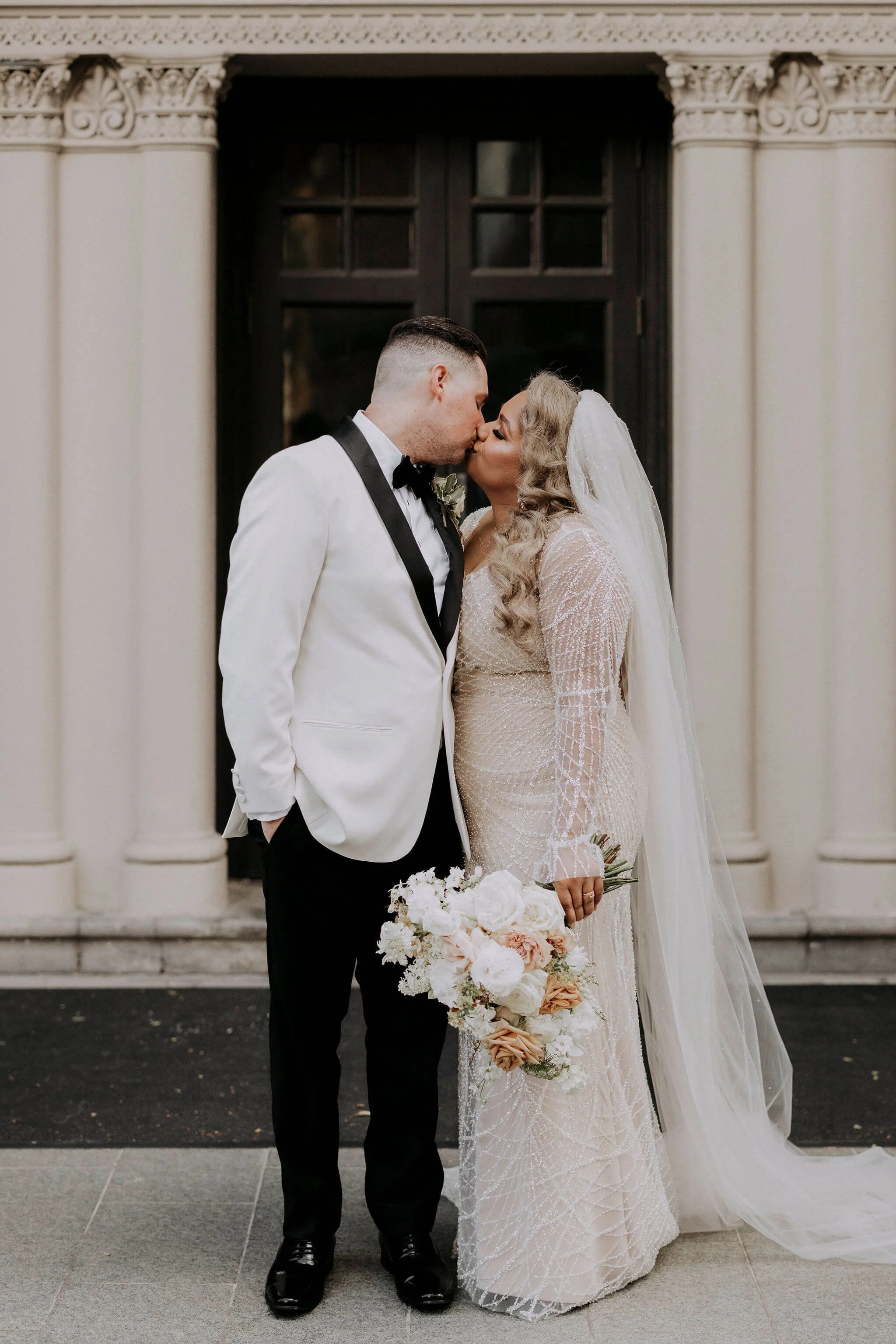 Bride and groom at Crown Perth with a romantic white and blush bridal bouquet