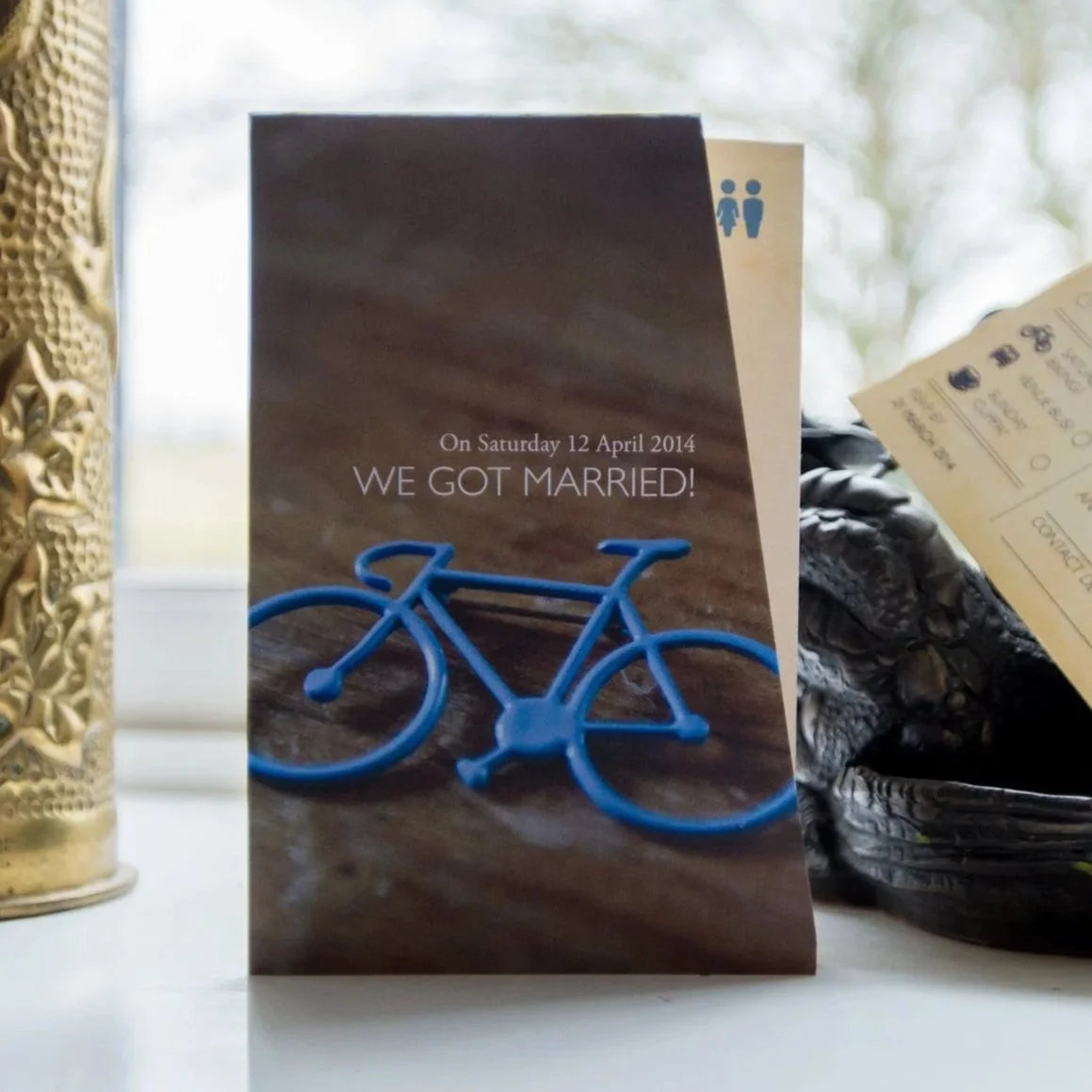 A wedding thank you card featuring an image of the bride's something blue - a blue bicycle broach.
