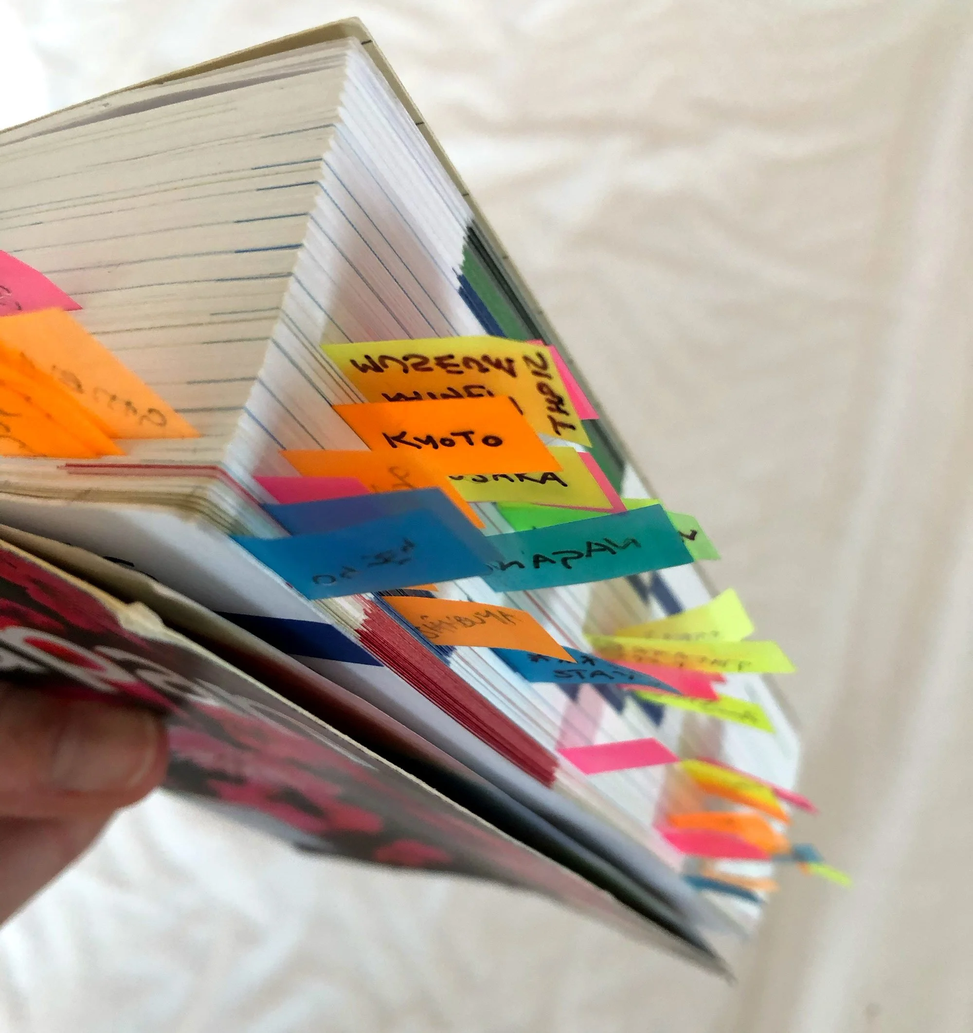 A close up view of brightly coloured sticky tabs marking important pages in a book