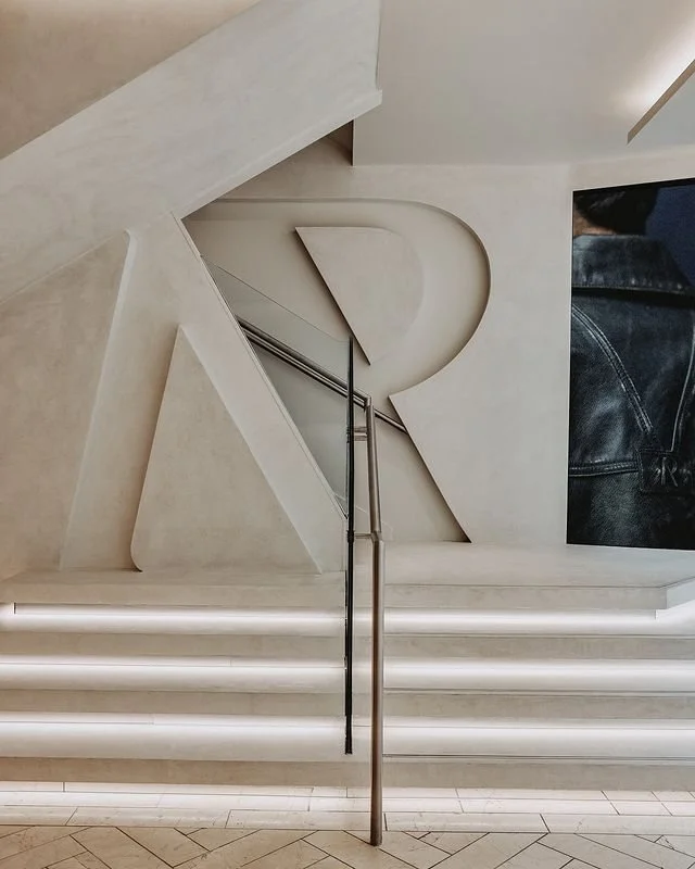 Bespoke microcement wall finishes and retail display areas at the Represent store in Manchester.