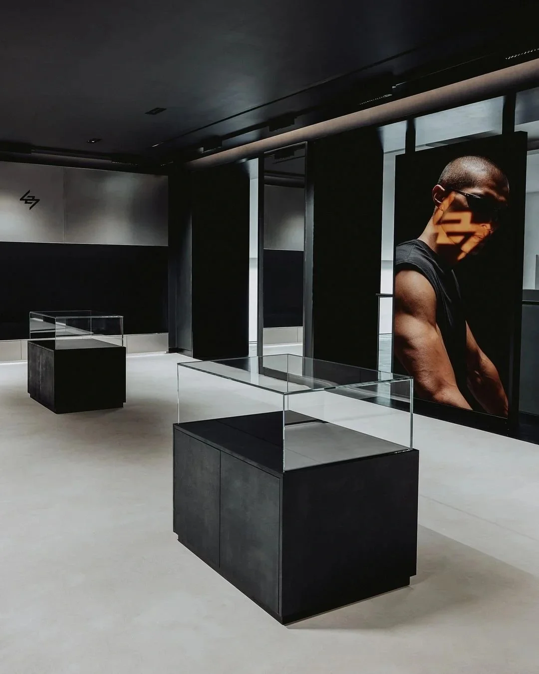 Modern retail showroom with polished concrete flooring, black display units, and minimalist interior design.