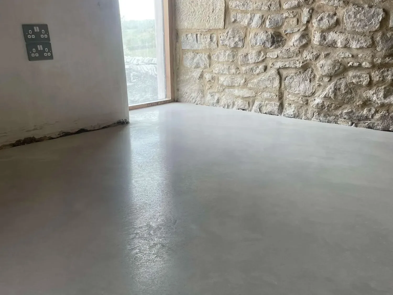 Polished concrete flooring in a modern minimalist hallway with arched ceiling and floating vanity.