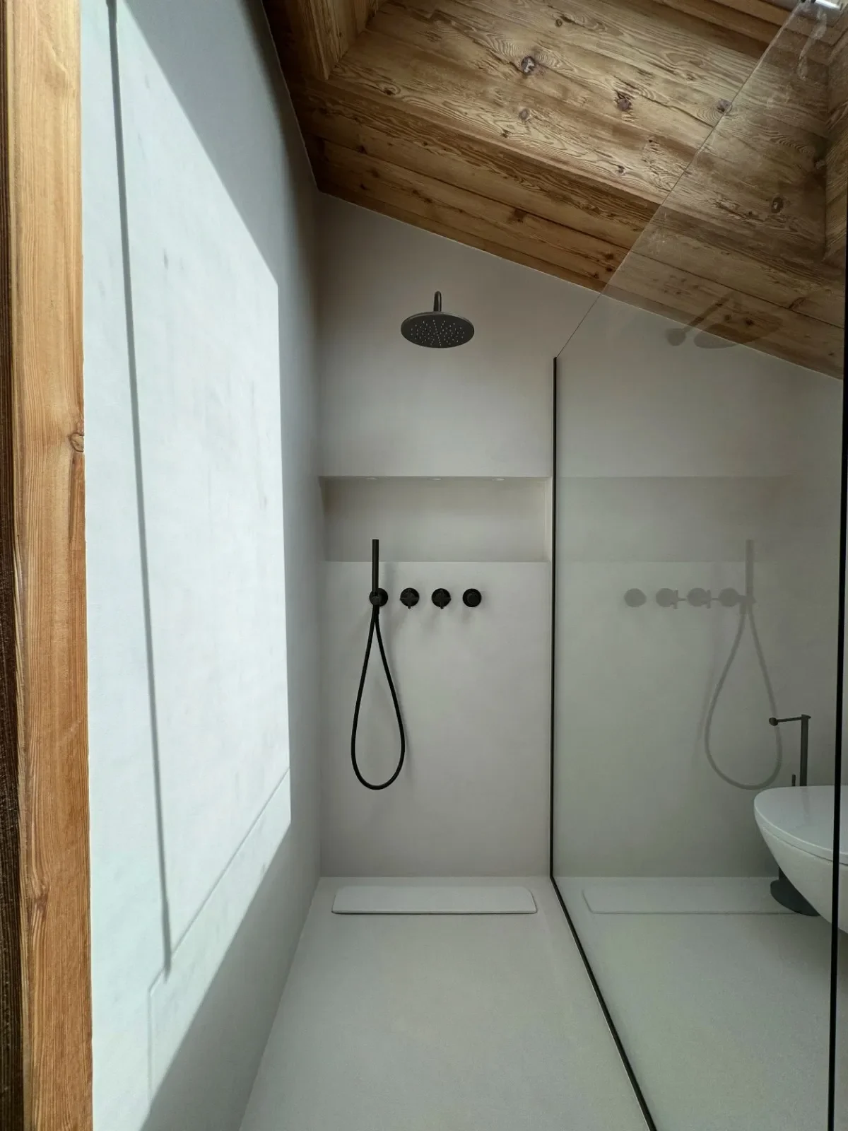 Microcement bathroom with minimalist design, arched ceiling, floating vanity, and soft neutral tones.