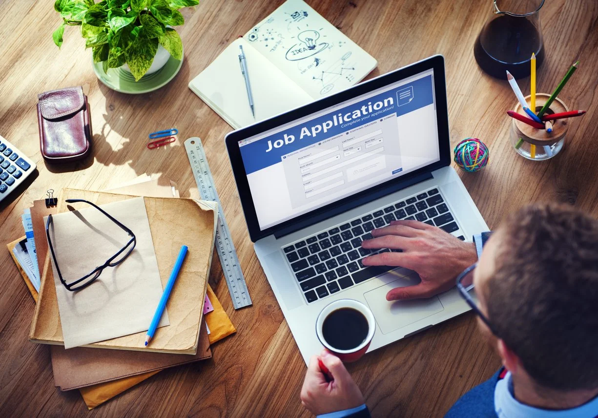 man-fills-out-job-application-as-part-of-job-search.jpg