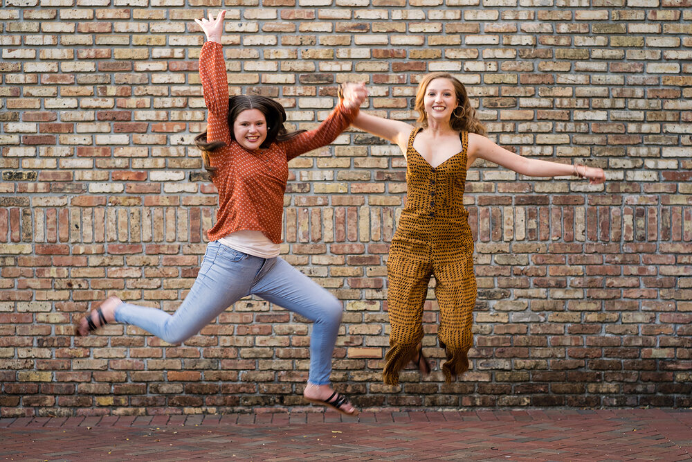 Teen Girls Jump in Front of Brick Wall Plantation Photographer