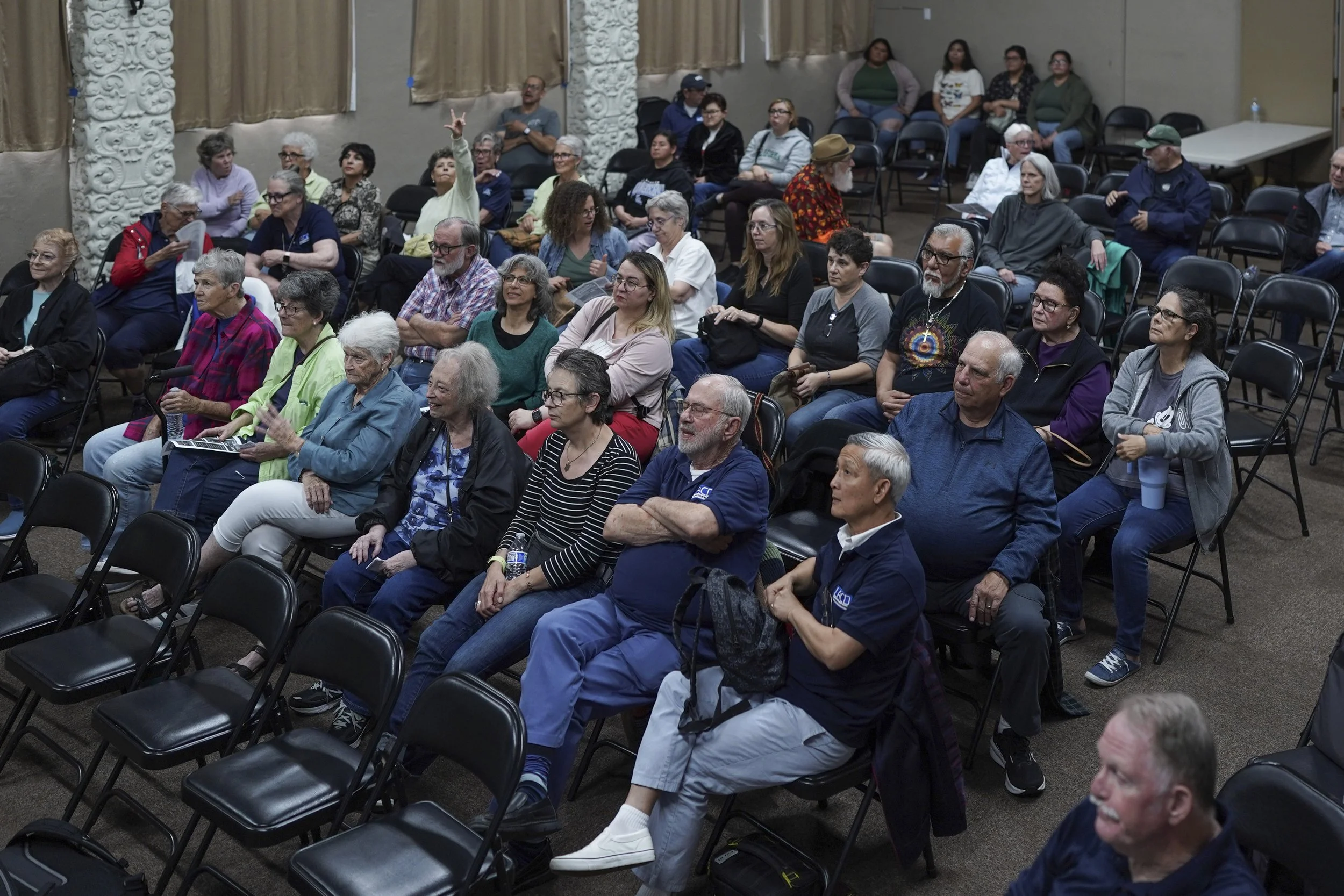 Audience members sit together in a community hall attending a screening of Being Michelle, reflecting engagement, curiosity, and collective listening.
