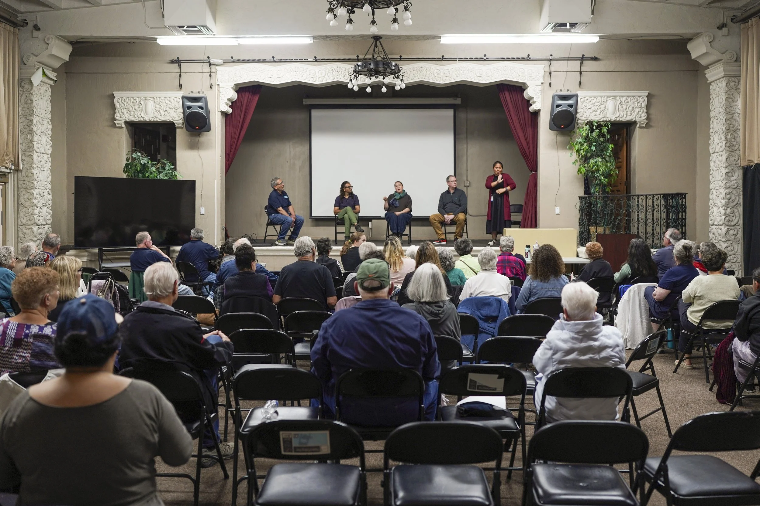 A full room of attendees participates in an impact screening of Being Michelle, emphasizing community engagement and shared reflection.