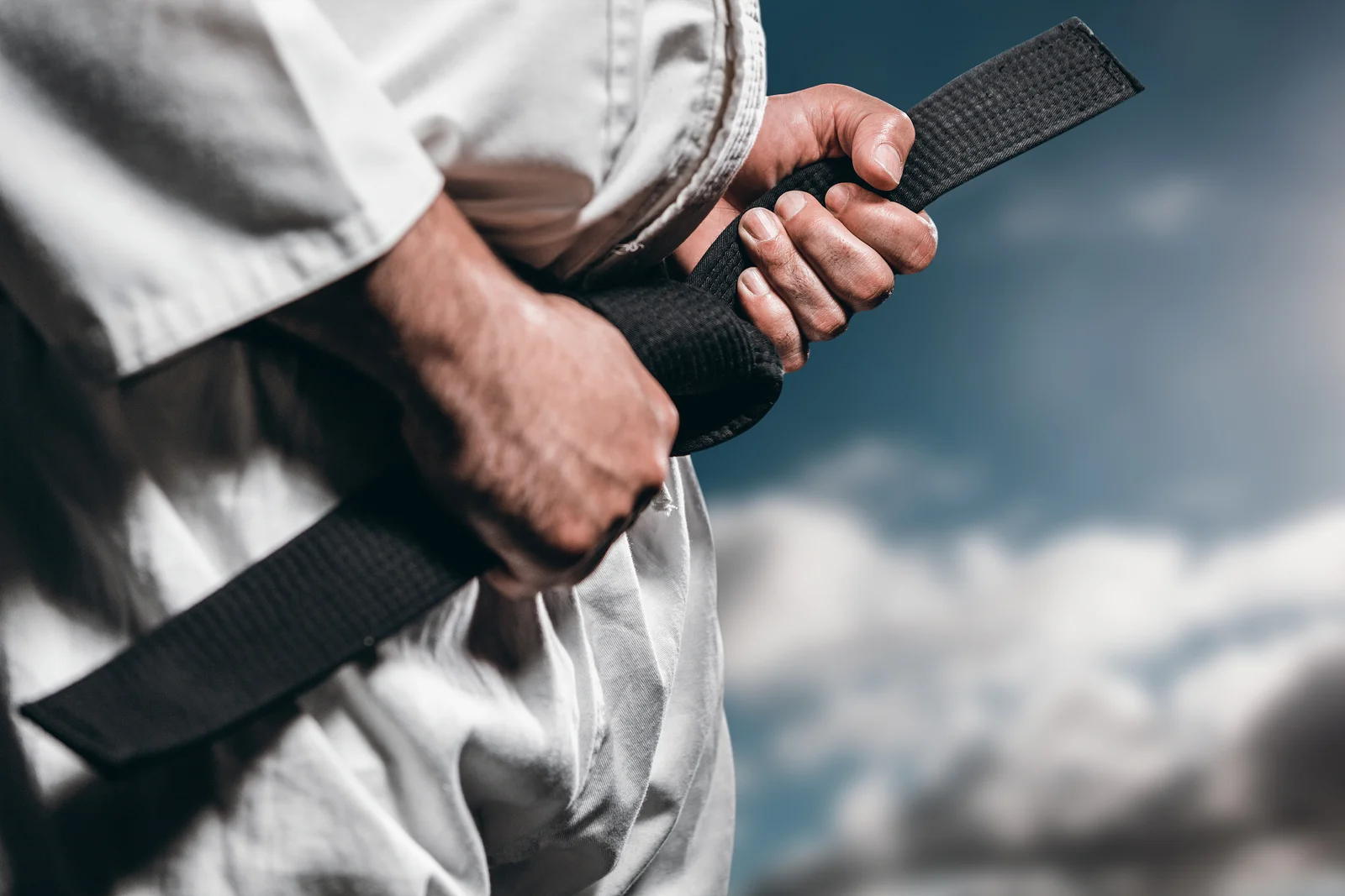 bigstock-Fighter-tightening-karate-belt-134406767.jpg