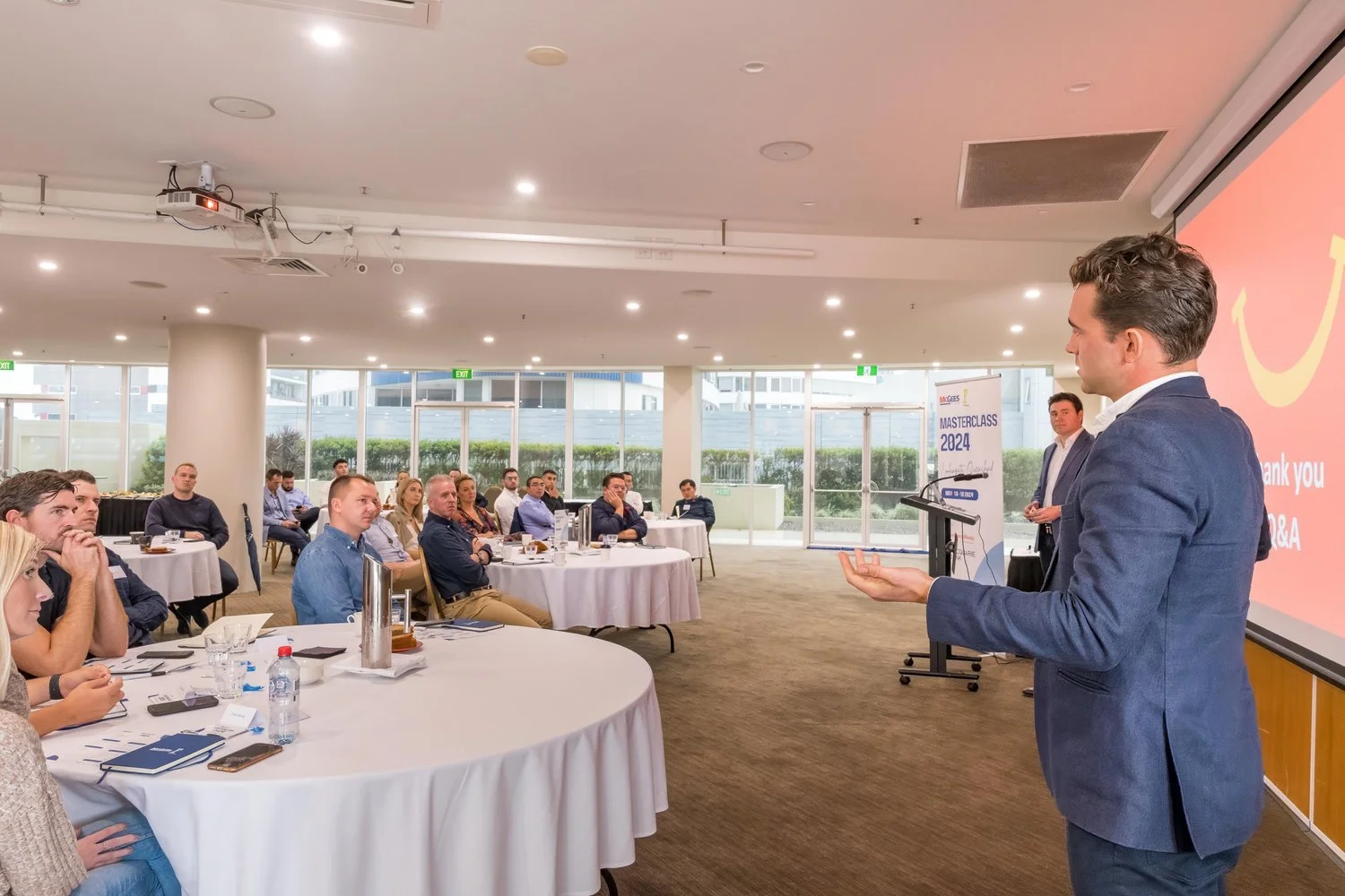 A speaker addressing attendees seated at round tables during the McGees Property Masterclass at Twin Towns Services Club near Coolangatta, captured by event photographer Scott Hardy