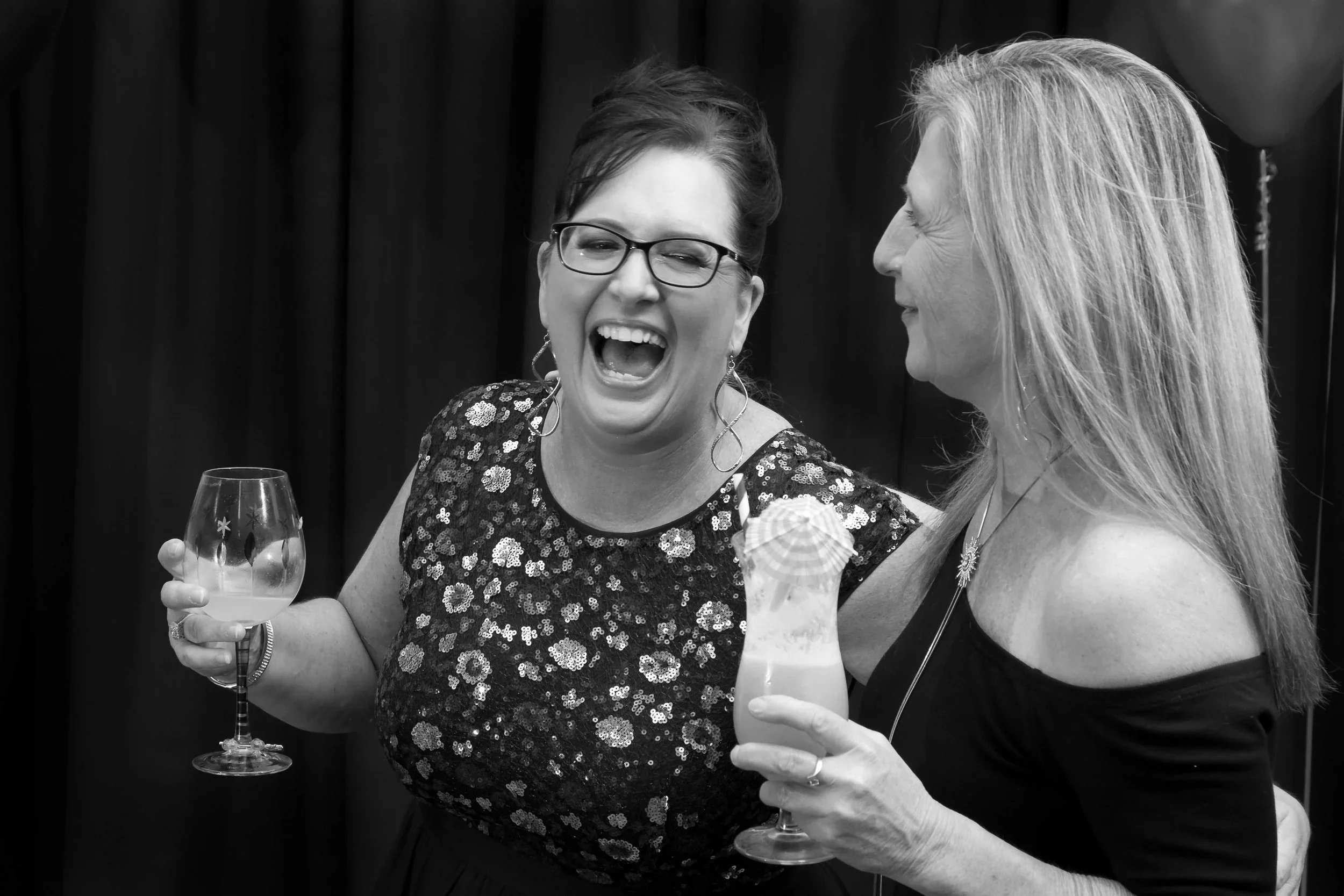 A woman laughing and celebrating her 50th birthday with a drink in hand during a photography session in Palm Beach on the Gold Coast, captured by Scott Hardy