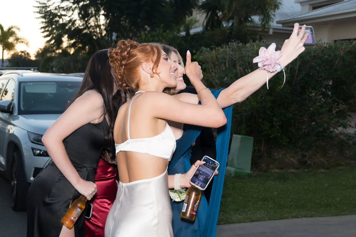 Students in formal dresses posing and celebrating during a pre-formal photography session in Carrara on the Gold Coast, captured by Scott Hardy