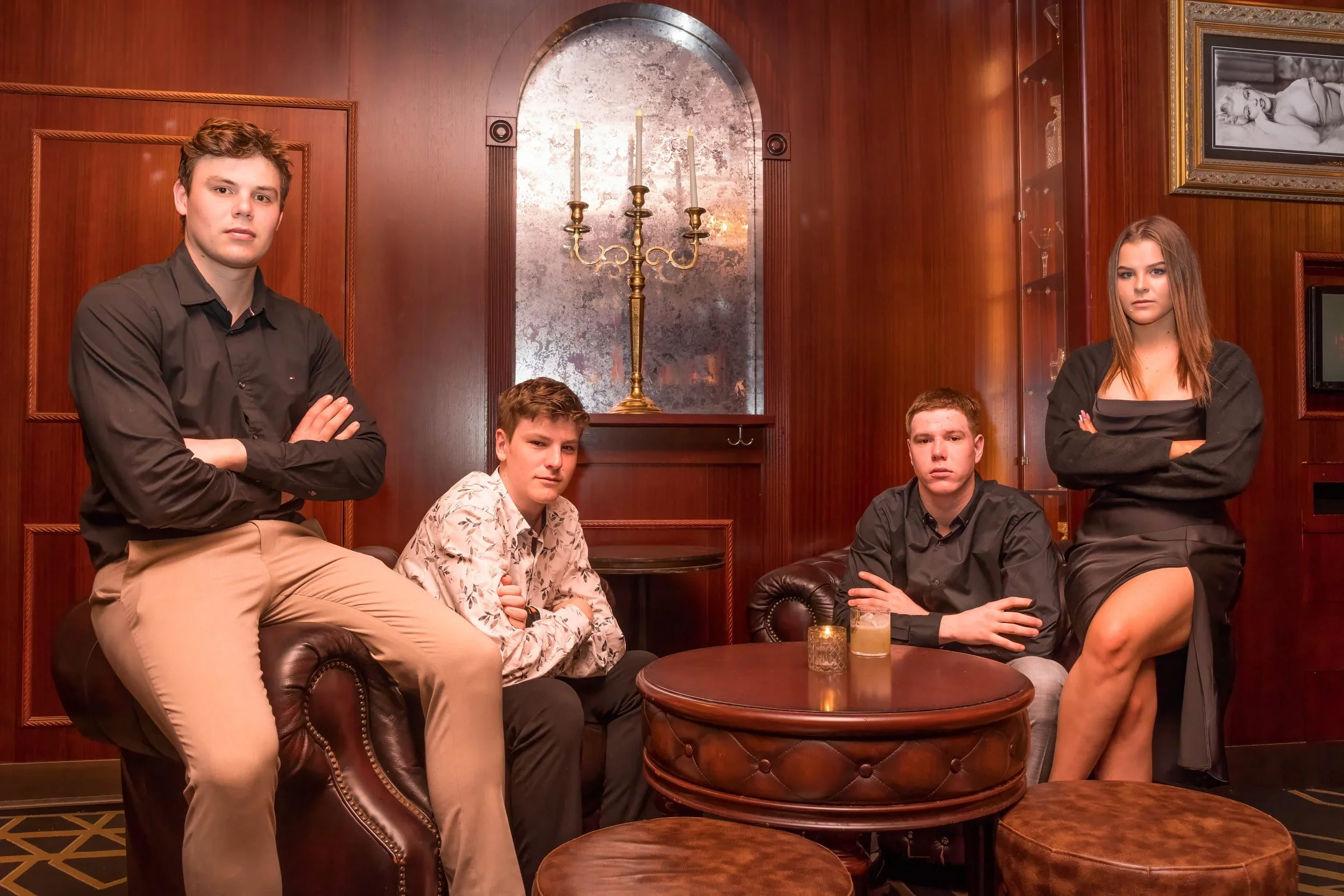 Four friends posing for a portrait in a wood-paneled bar booth during a 21st birthday celebration in Broadbeach on the Gold Coast, captured by event photographer Scott Hardy