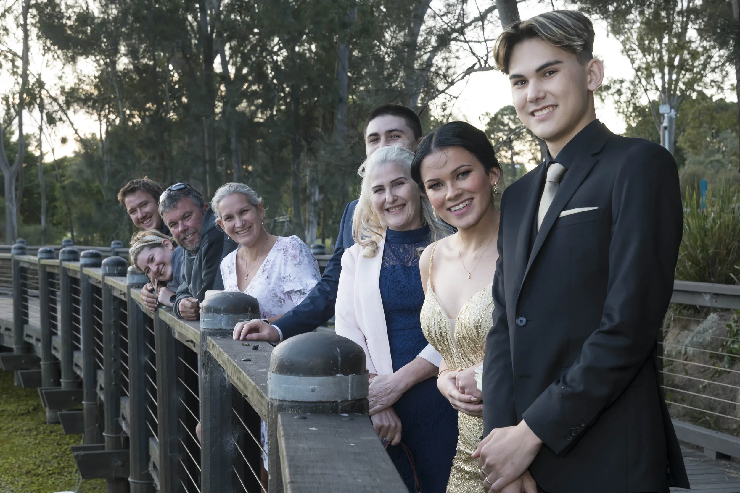 Students and family members posing on a boardwalk during a pre-formal photography session at the Gold Coast Regional Botanic Gardens in Benowa, captured by Scott Hardy