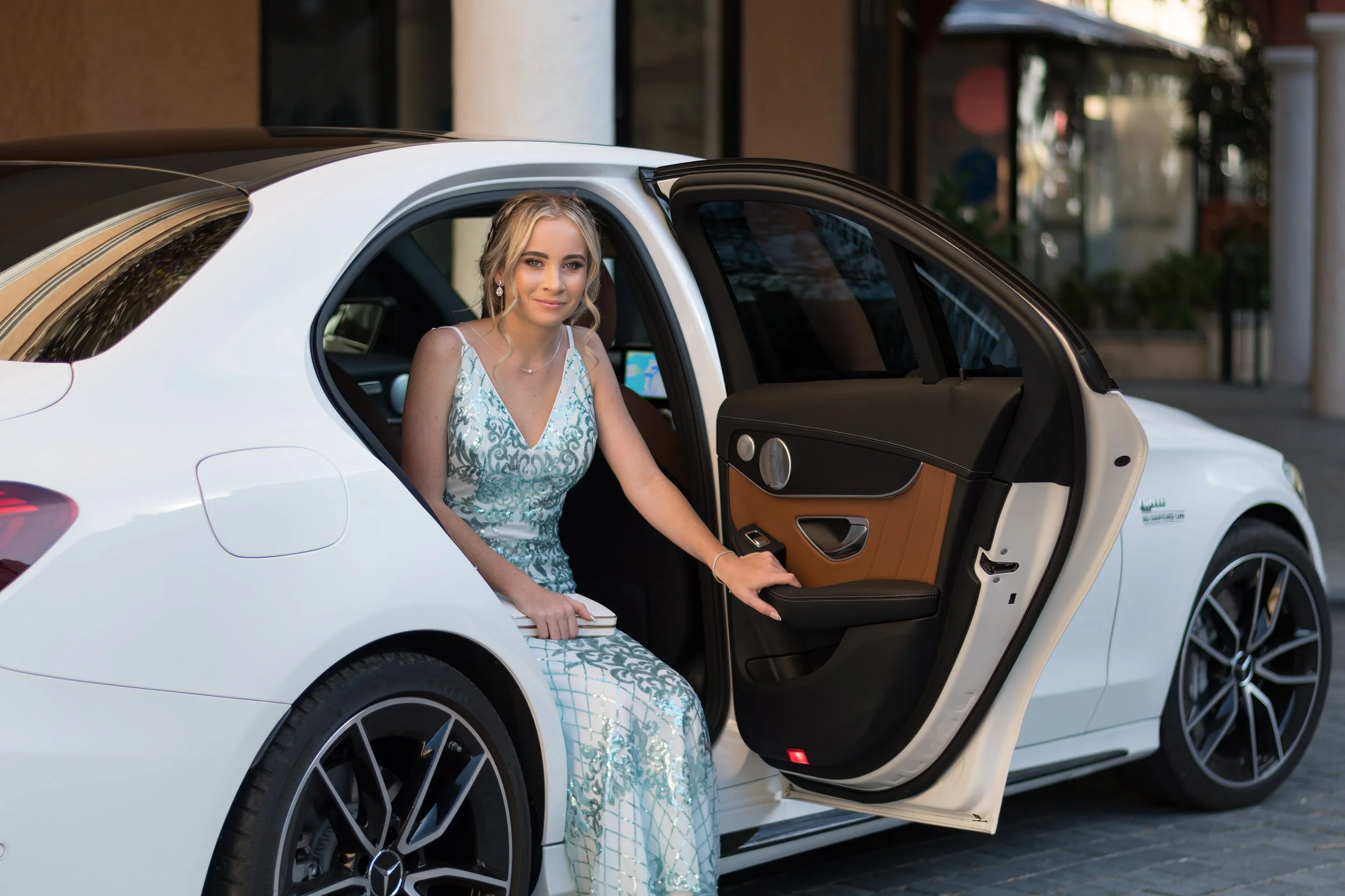 A student in a formal dress stepping out of a luxury car at Emerald Lakes on the Gold Coast, captured by pre-formal photographer Scott Hardy
