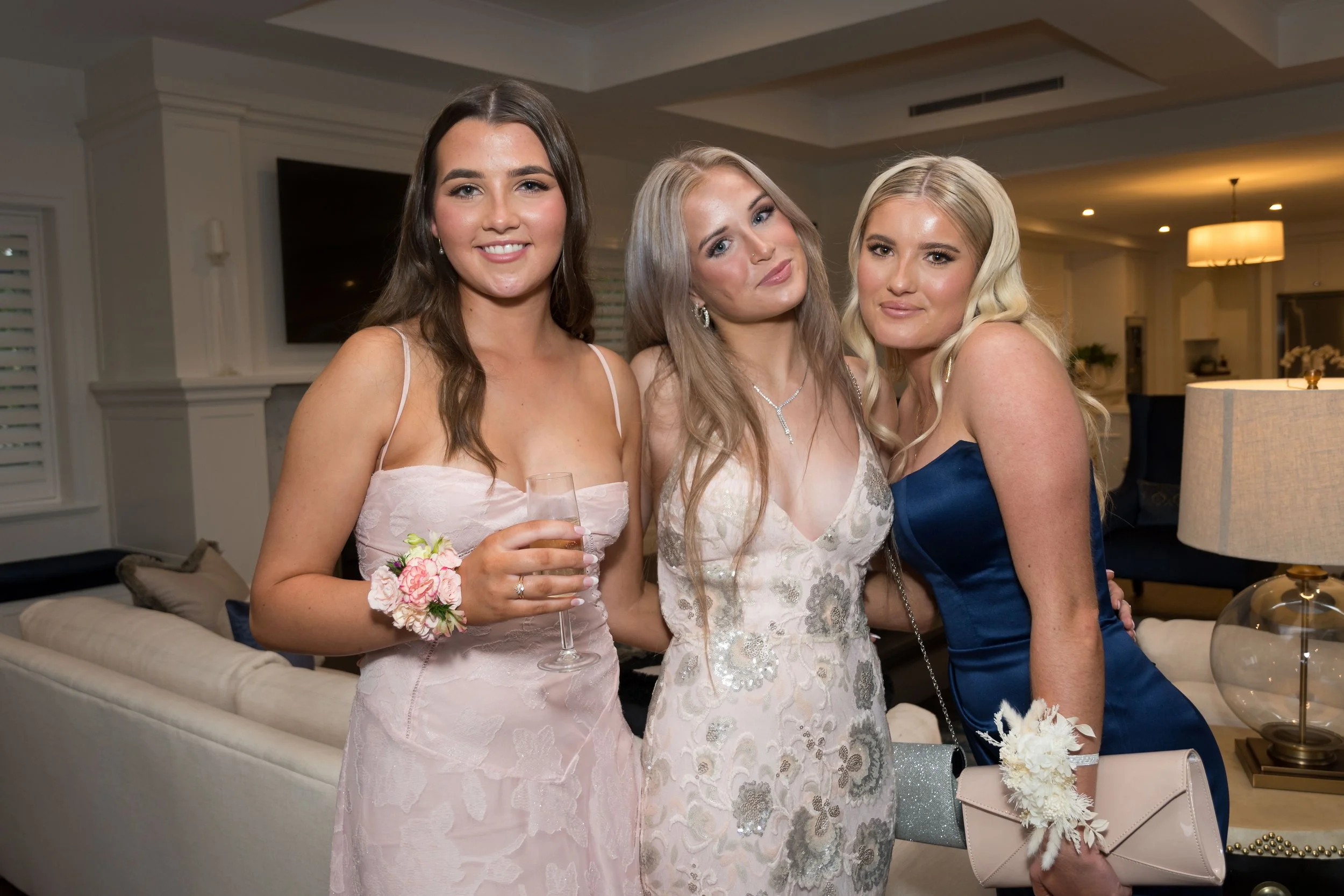 Students in formal dresses with wrist corsages posing indoors during a pre-formal photography session in Benowa on the Gold Coast, captured by Scott Hardy.