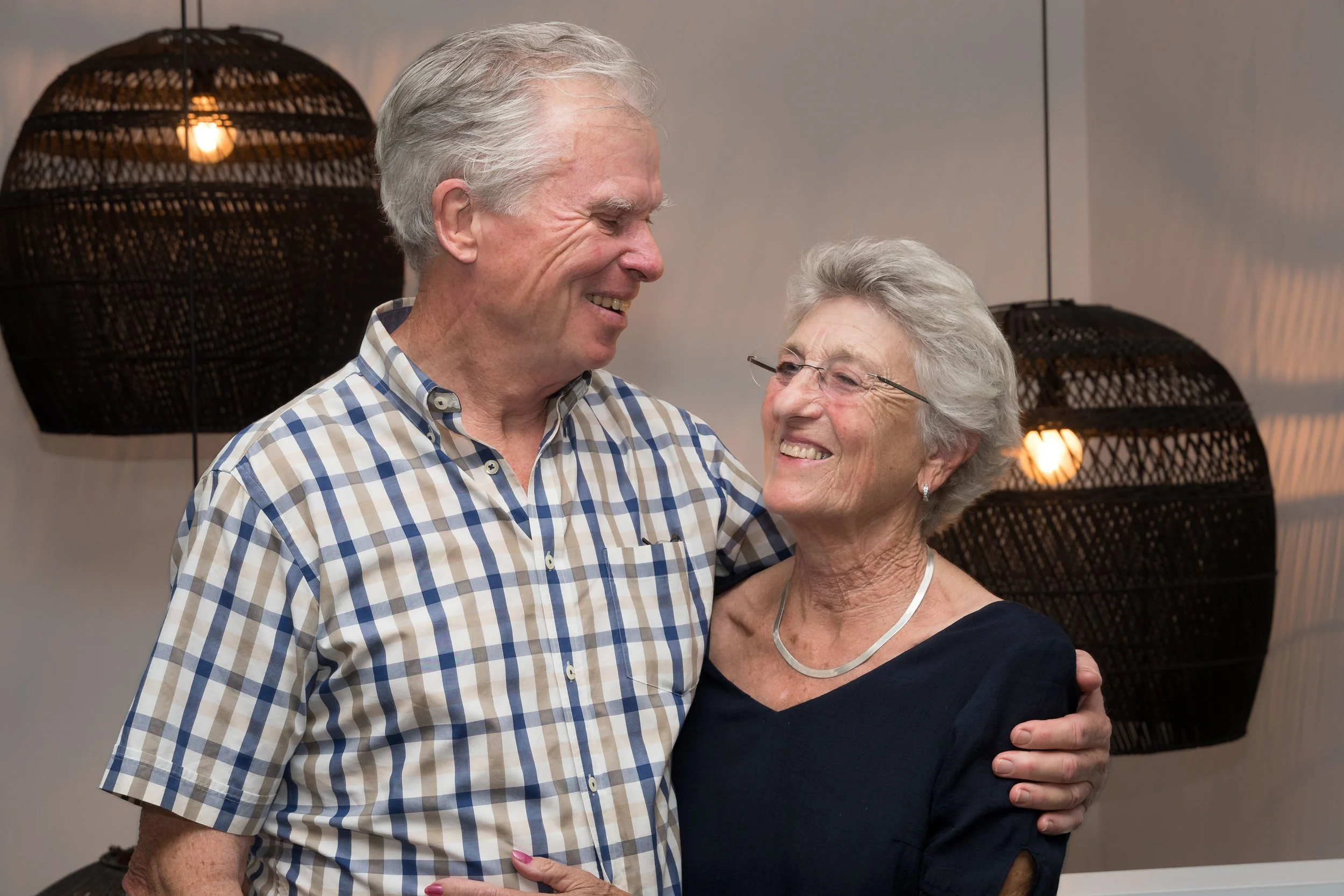 A couple laughing together during their wedding anniversary celebration while visiting the Gold Coast from Melbourne.