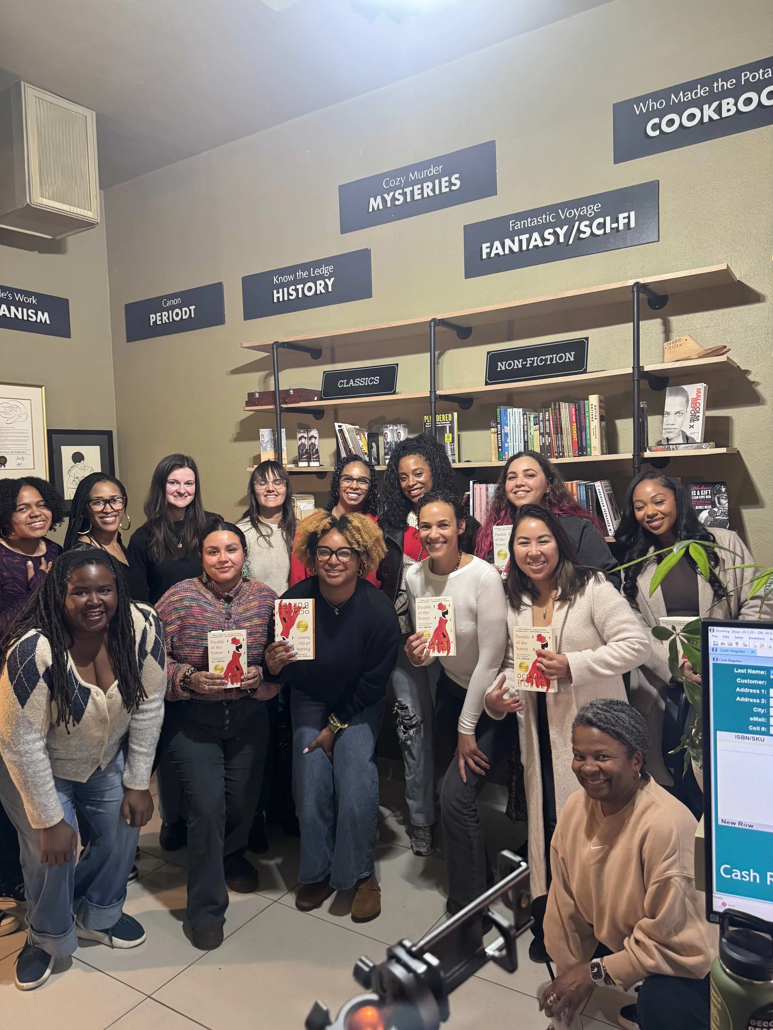 A group of people holding up Parable of the Sower in a bookshop