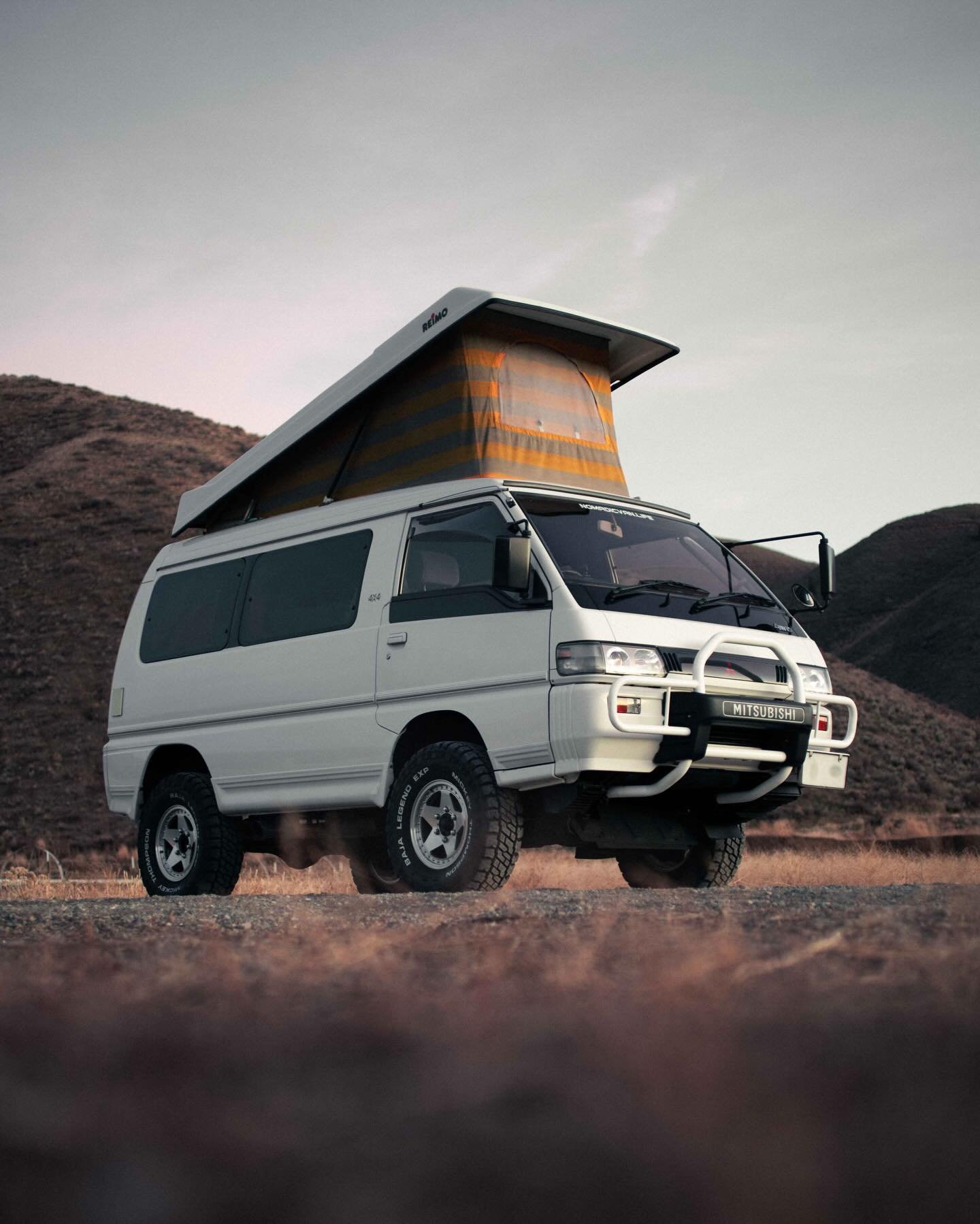 Meet Moa, a 1993 Delica L300 Star Wagon Reimo Pop Top Camper built like a pocket expedition rig with a soft spot for slow mornings and long dirt roads. Finished in factory white and riding on 31-inch Mickey Thompson Baja Legends, Moa pairs classic L3