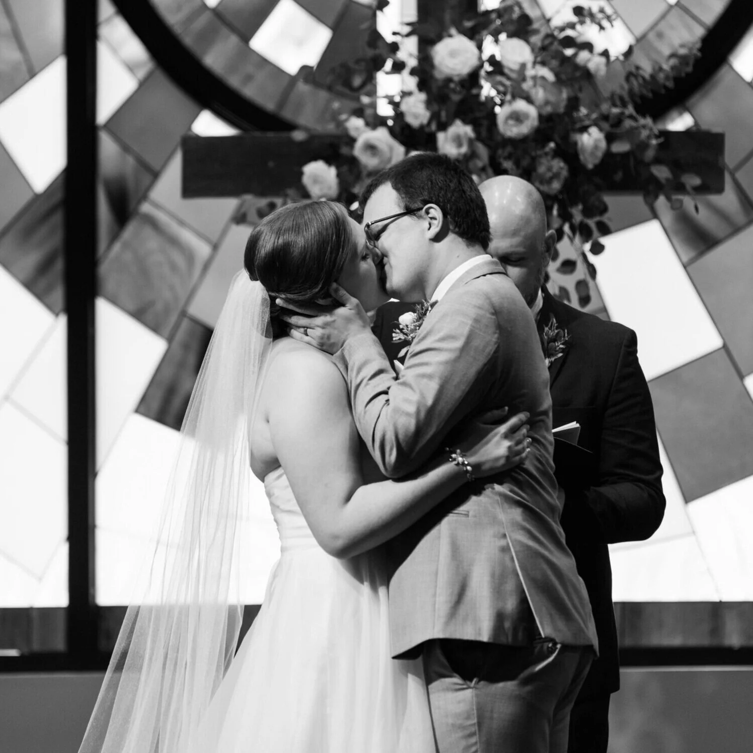 A black-and-white photo of a couple sharing their first kiss