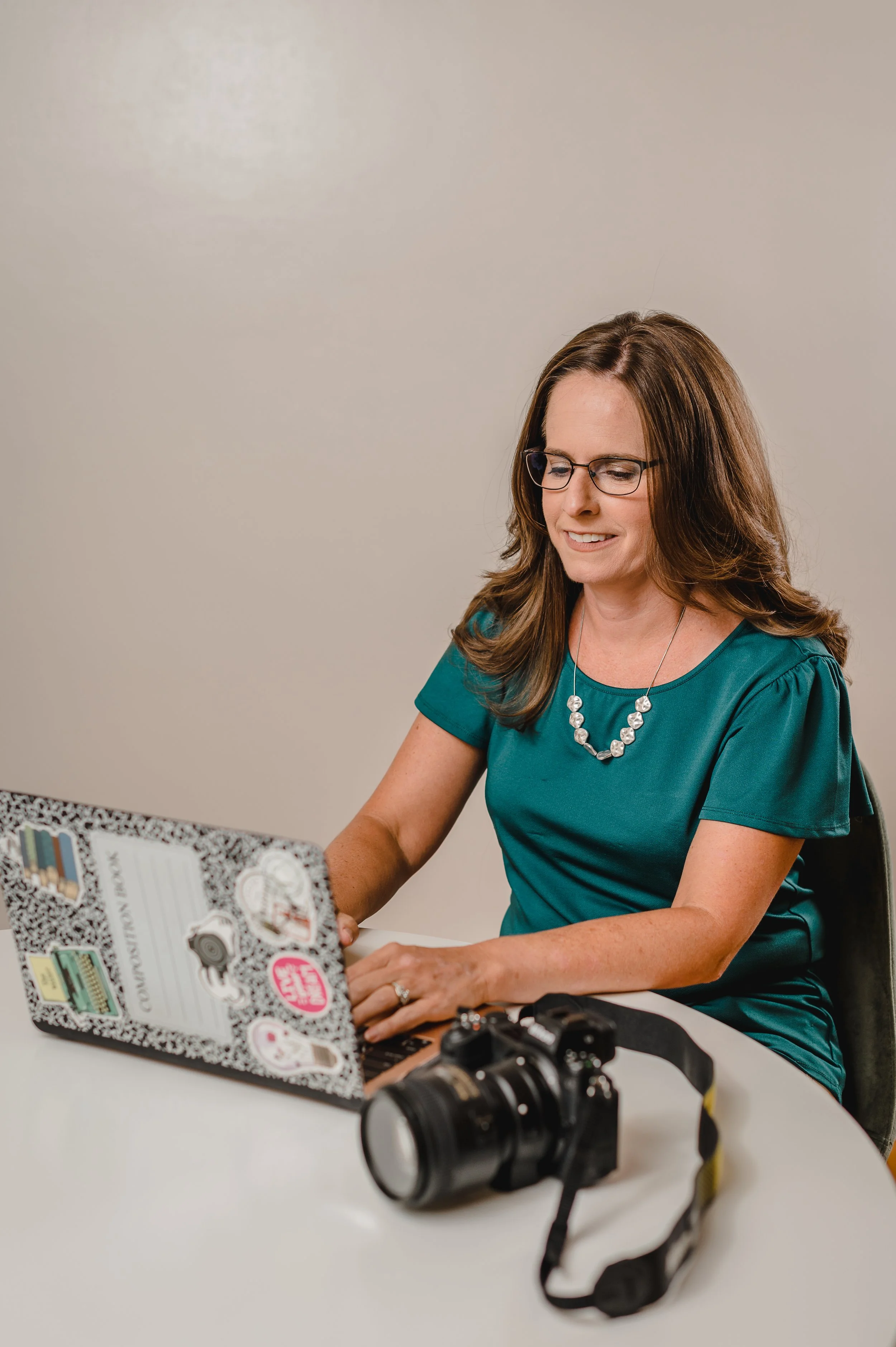 A photographer and small business owner works at computer to communicate effectively with clients