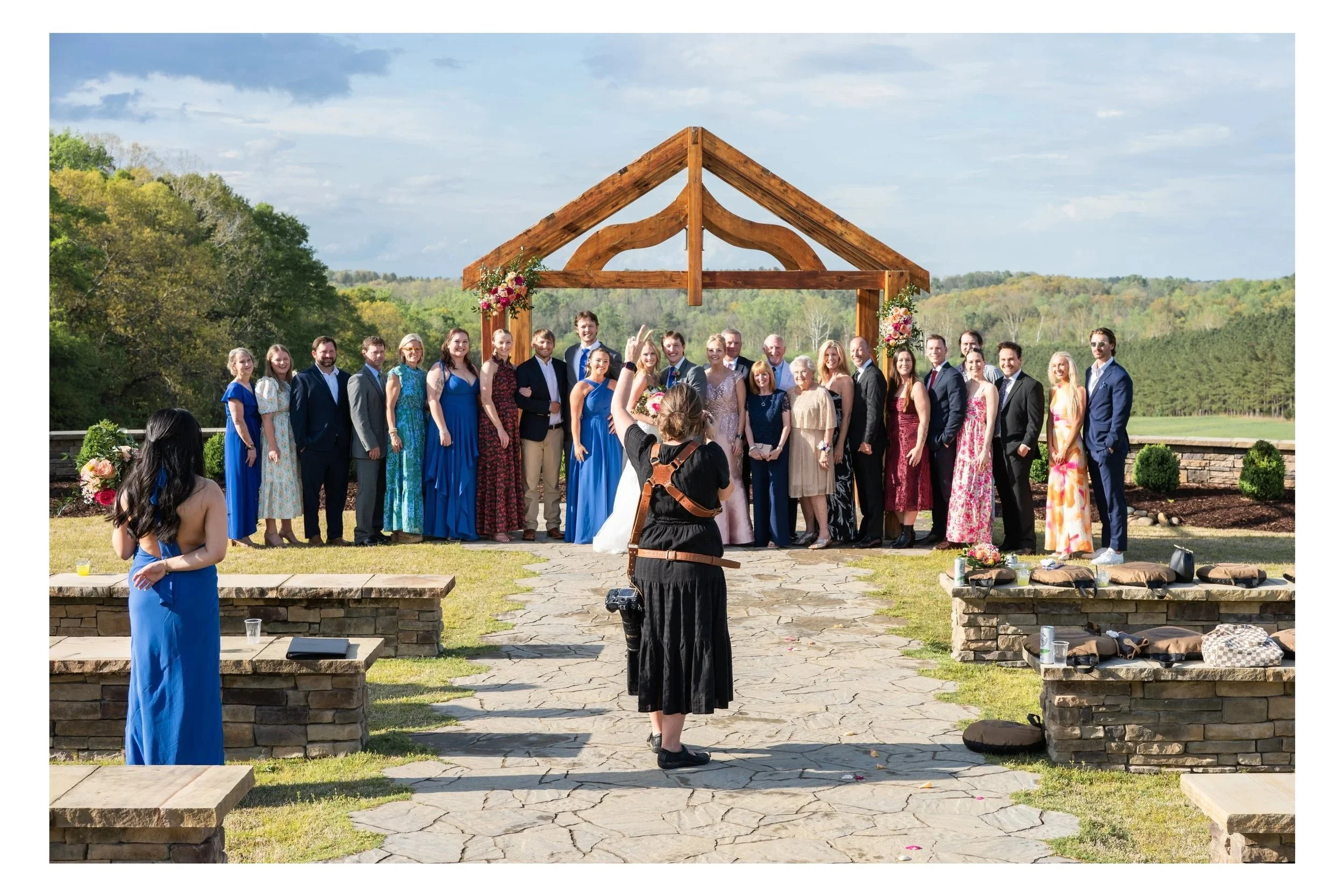 Photographer photographs large family photo in the ceremony space of Turkey Ridge, a wedding and event venue in Shelby, NC, overlooking the foothills of NC.